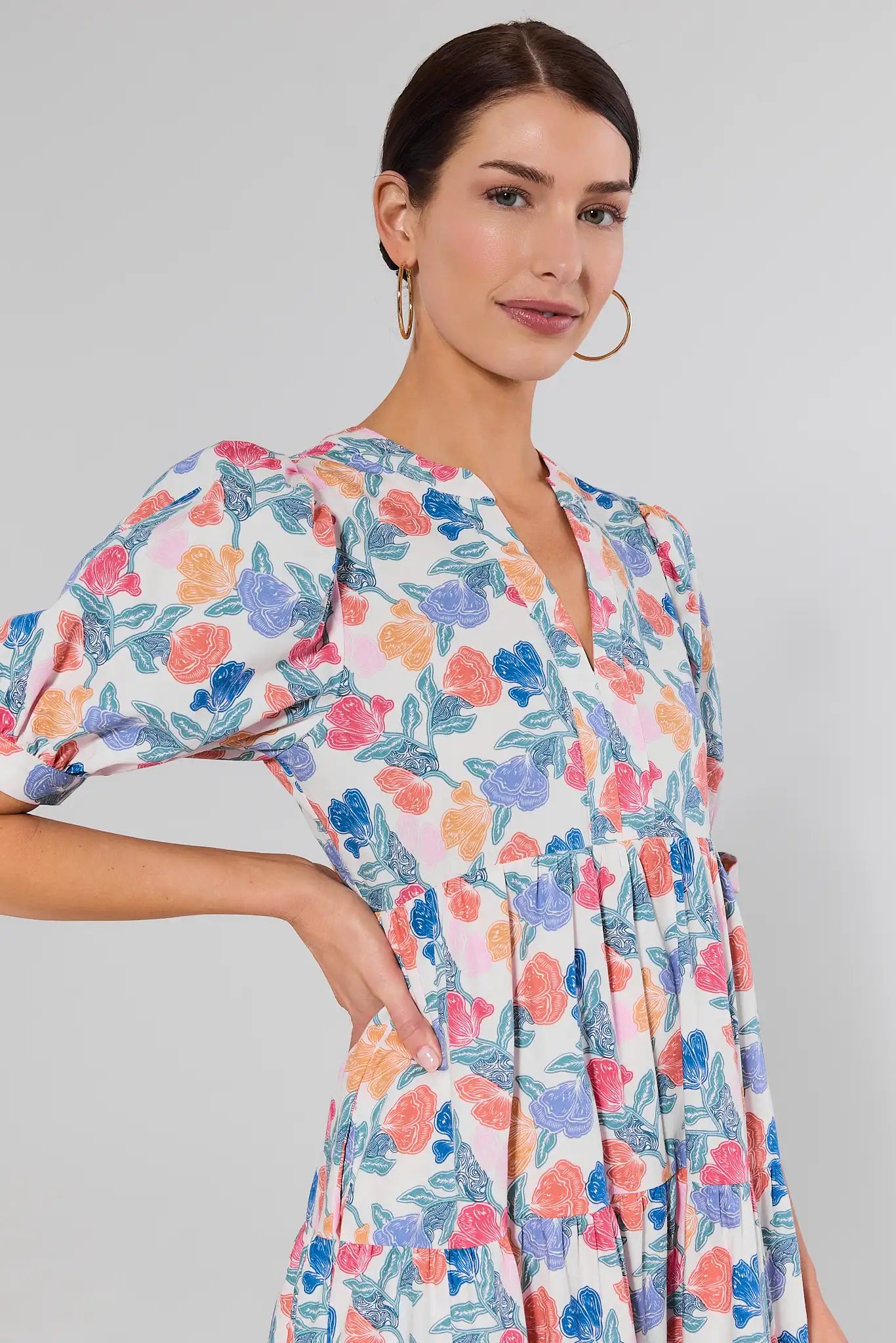 close up Woman wearing a floral dress against a plain background