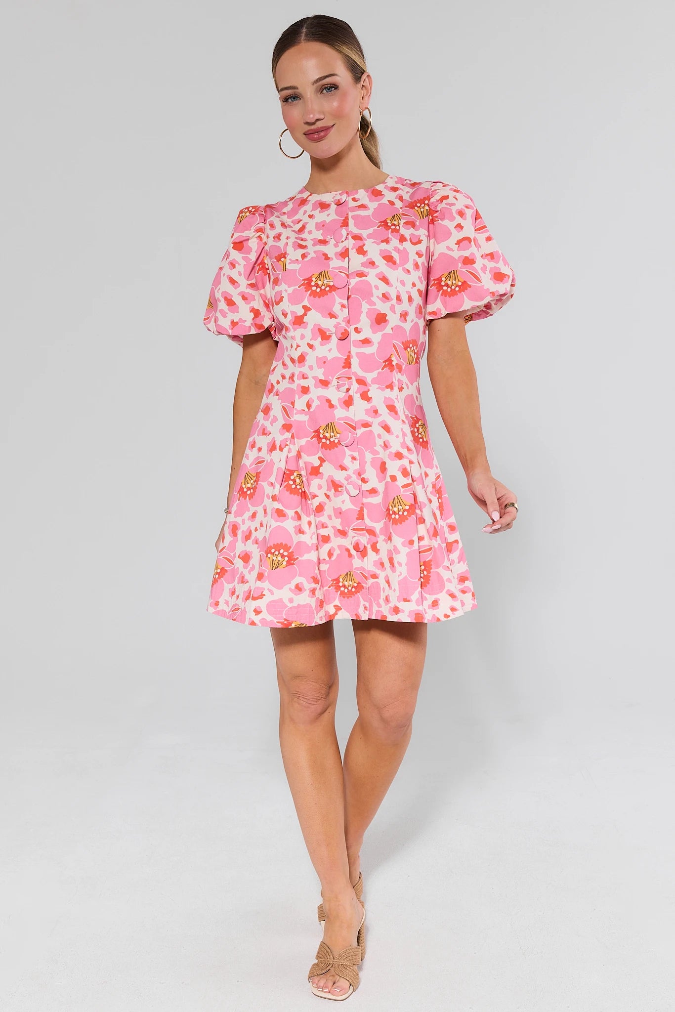Woman wearing a pink ruth floral dress on a gray background