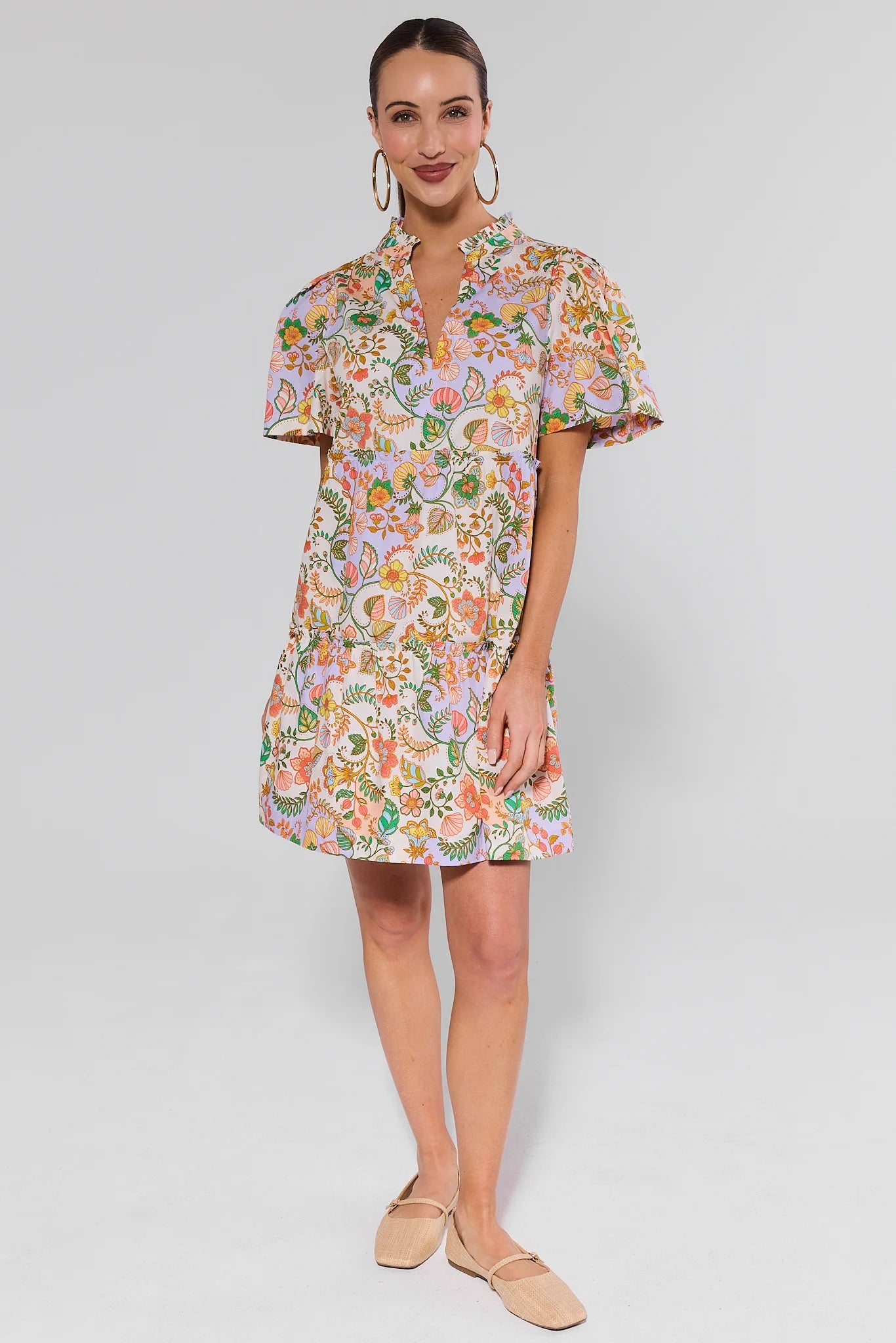 Woman wearing a floral dress on a plain background