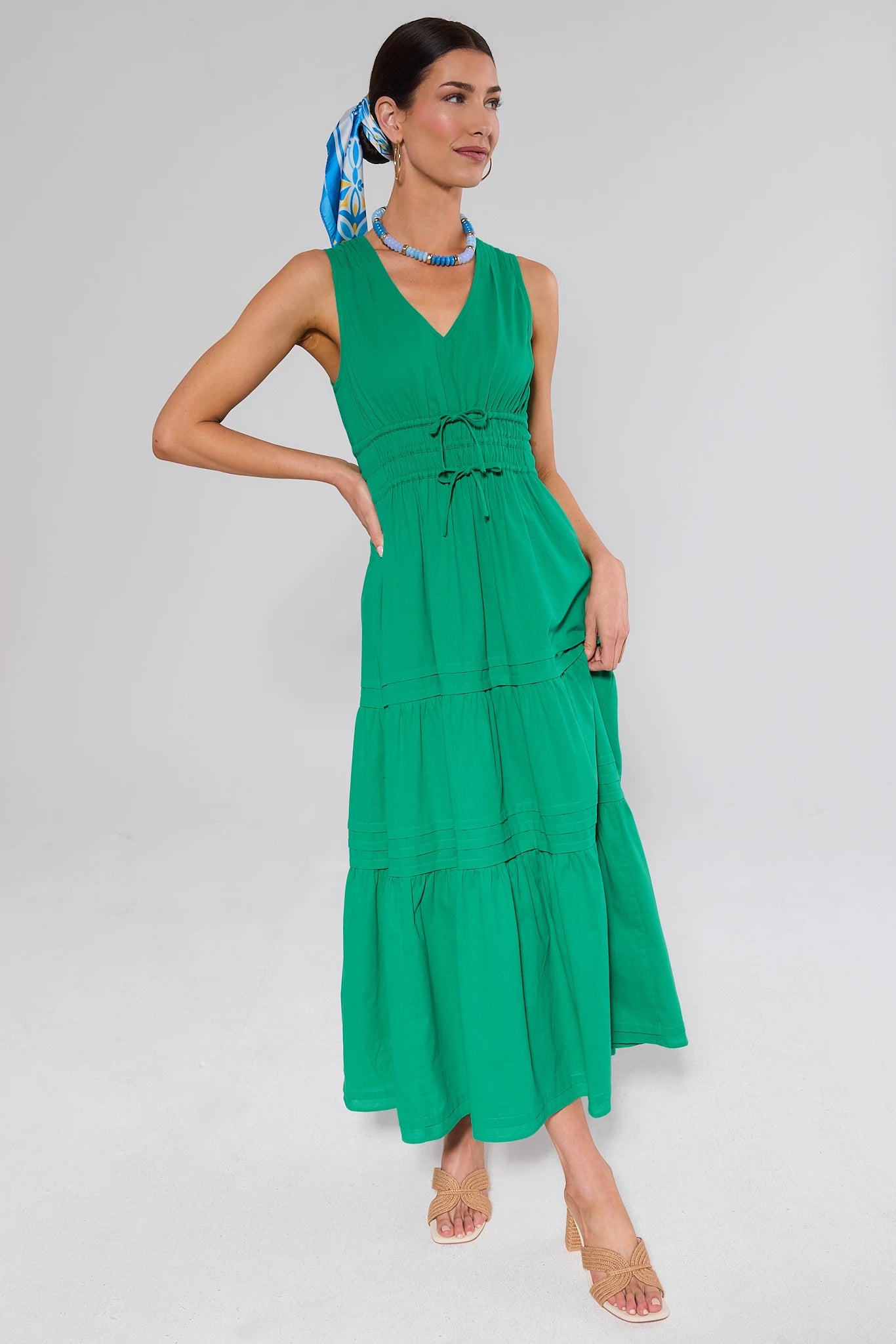side shot Woman wearing a green dress with a white background