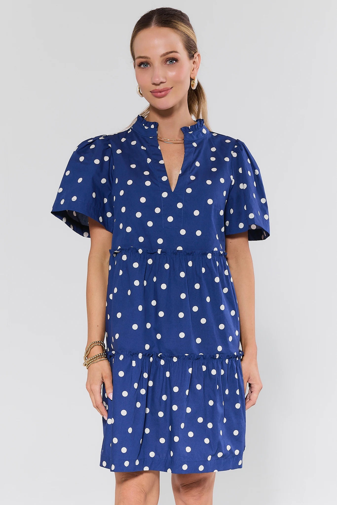 Woman wearing a blue dress with dots on a plain background