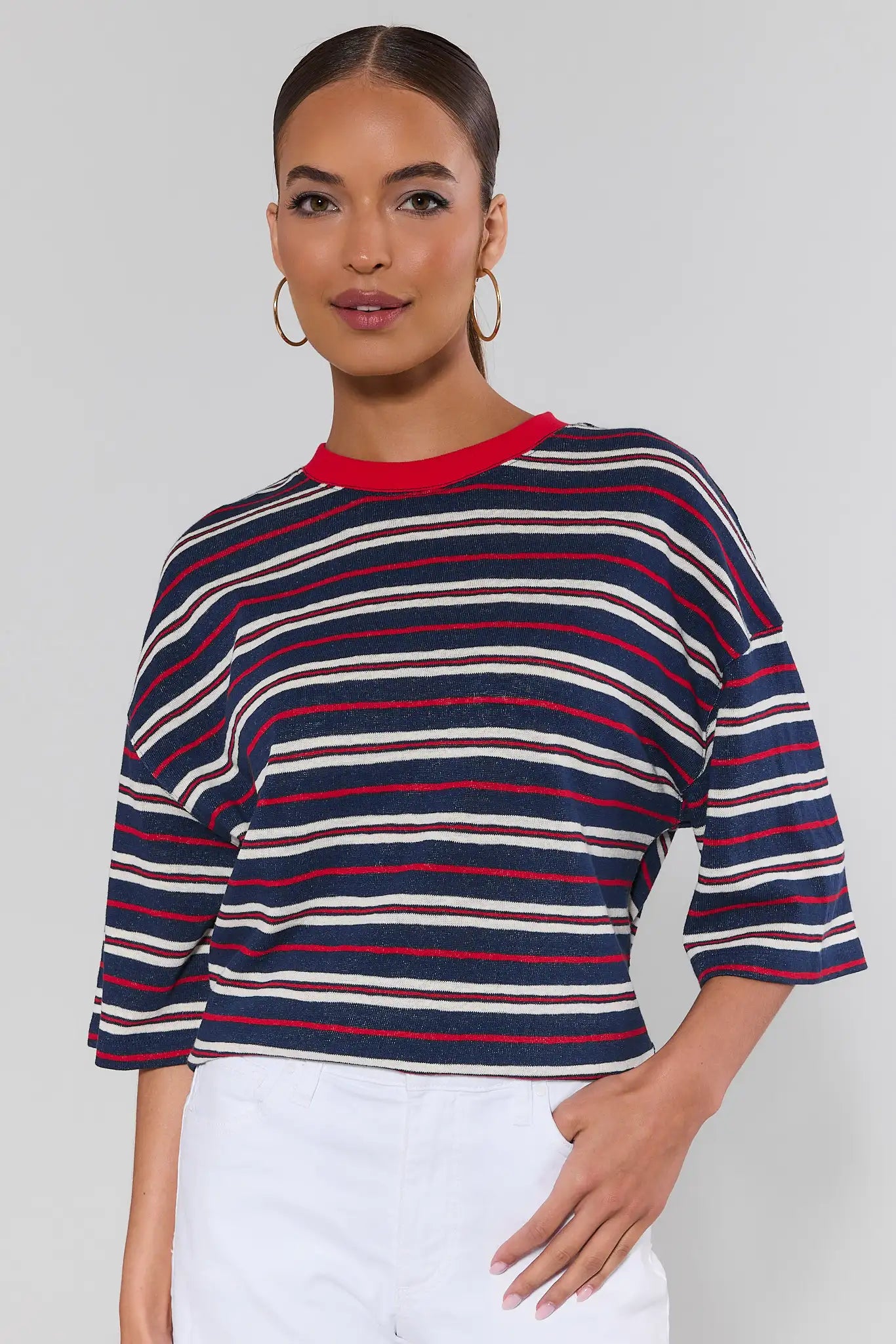 Woman wearing a striped sweater with a plain background