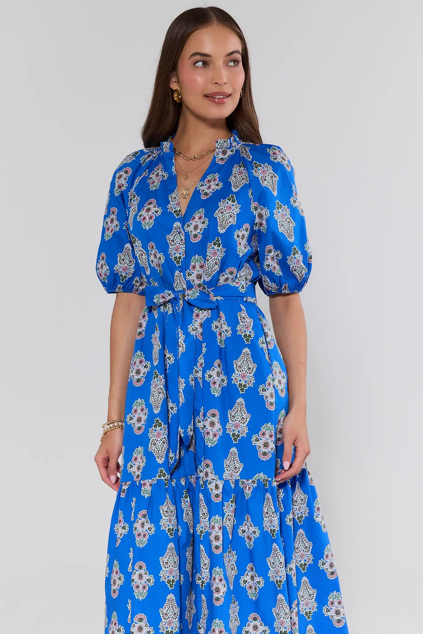 Woman wearing a blue floral dress against a white background