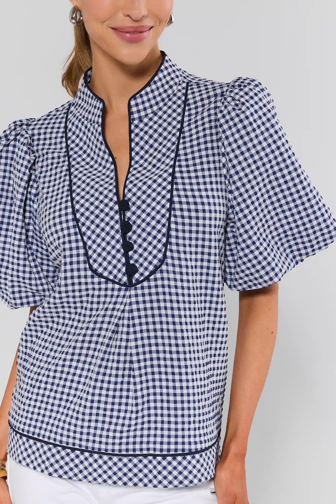 close up Woman wearing a blue and white checkered blouse with a plain background