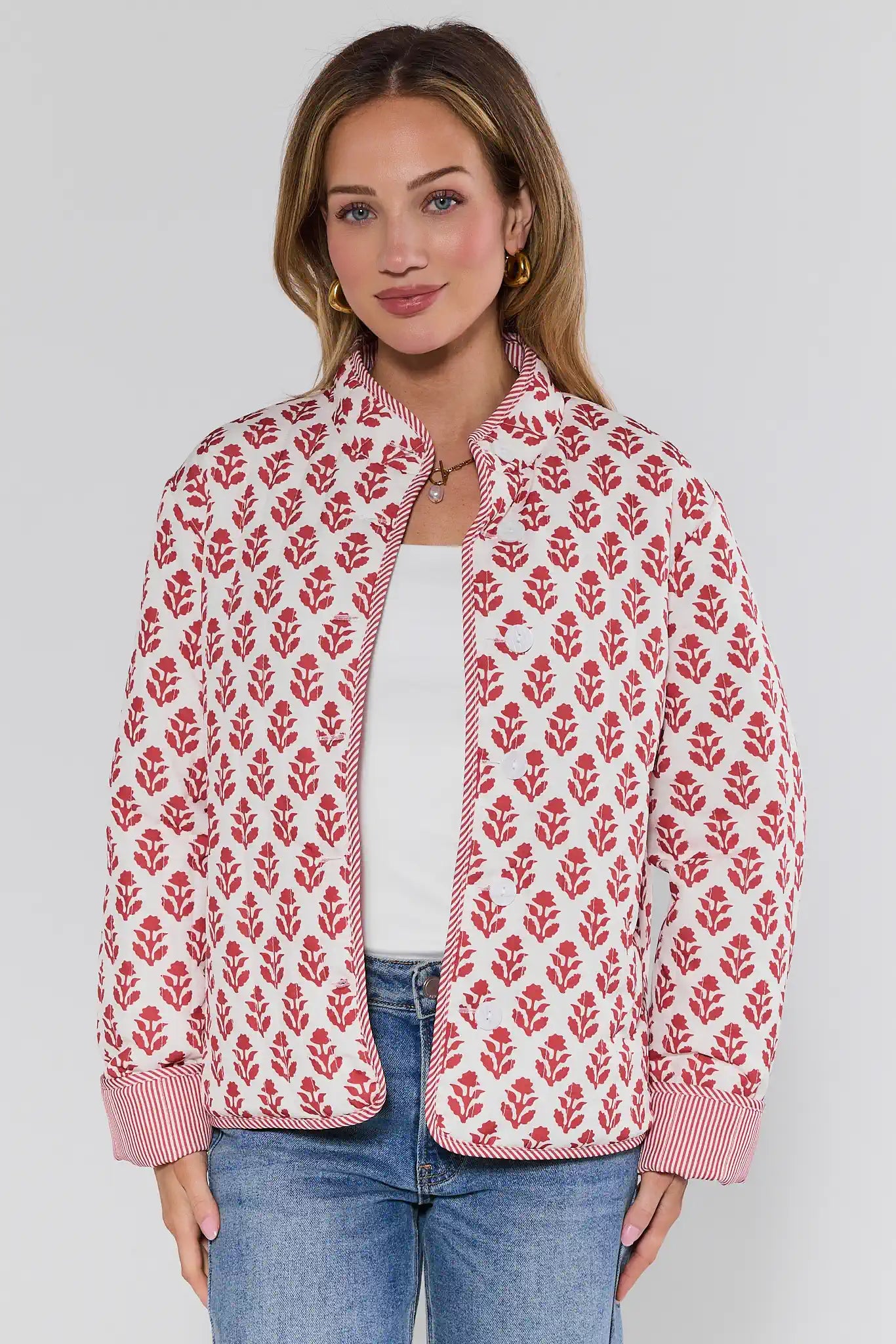 Woman wearing a red floral patterned jacket on a white background