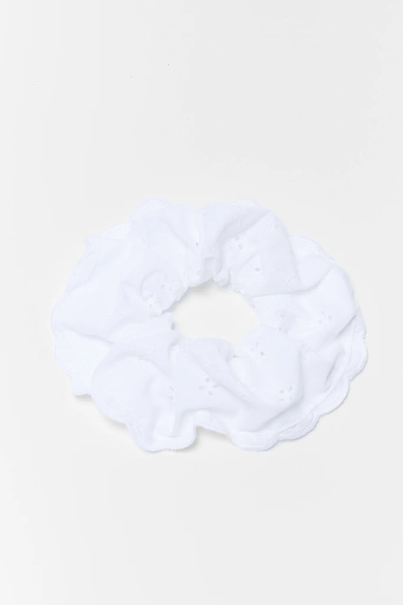 White scrunchie on a light beige background