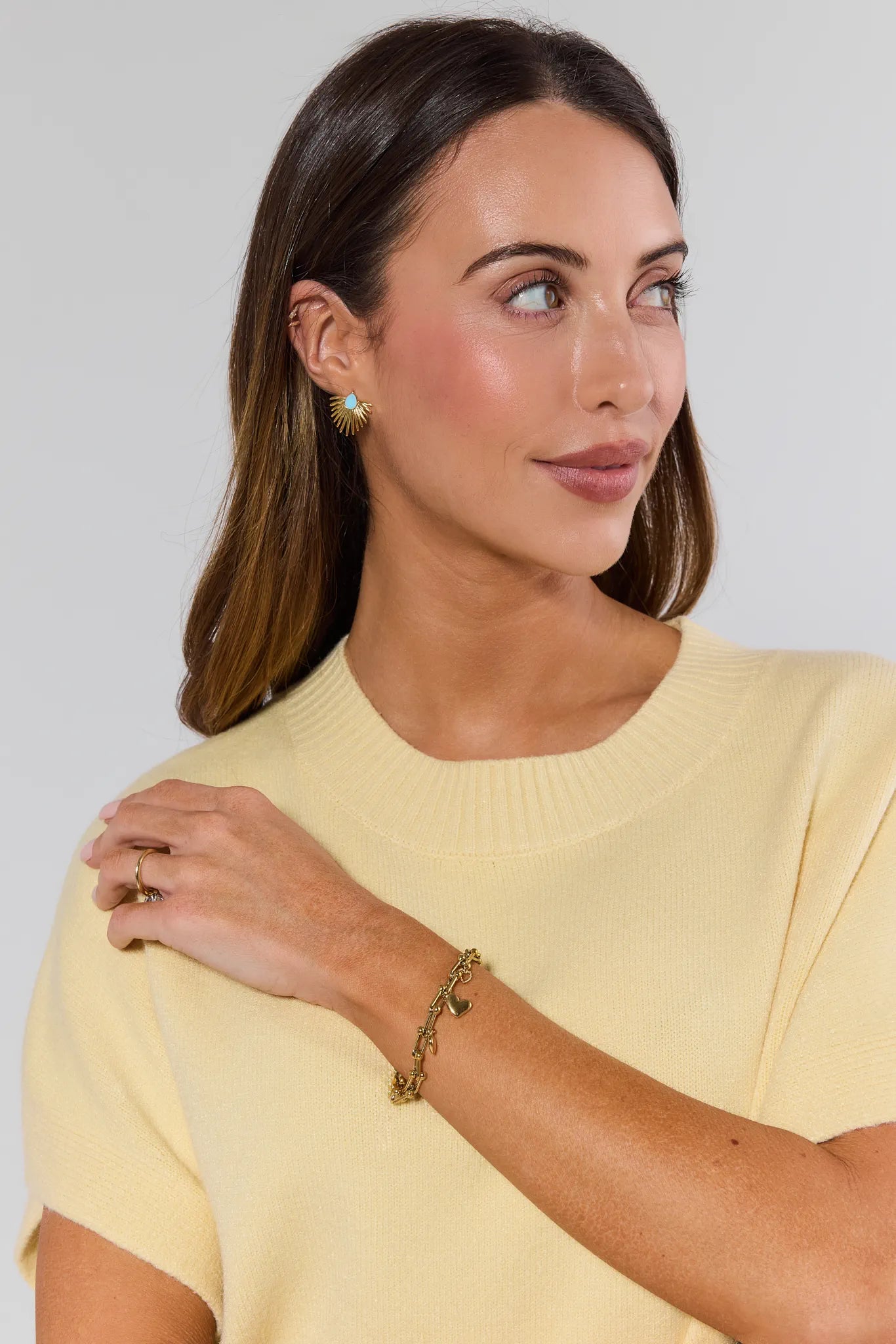 Woman wearing a yellow top with a plain background