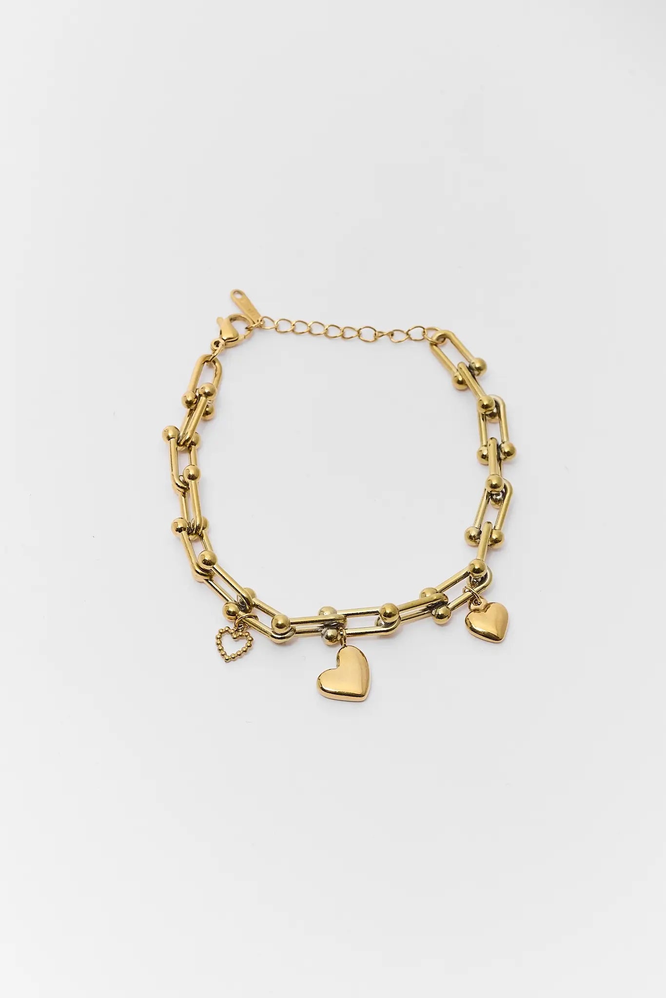 Gold bracelet with heart charms on a white background