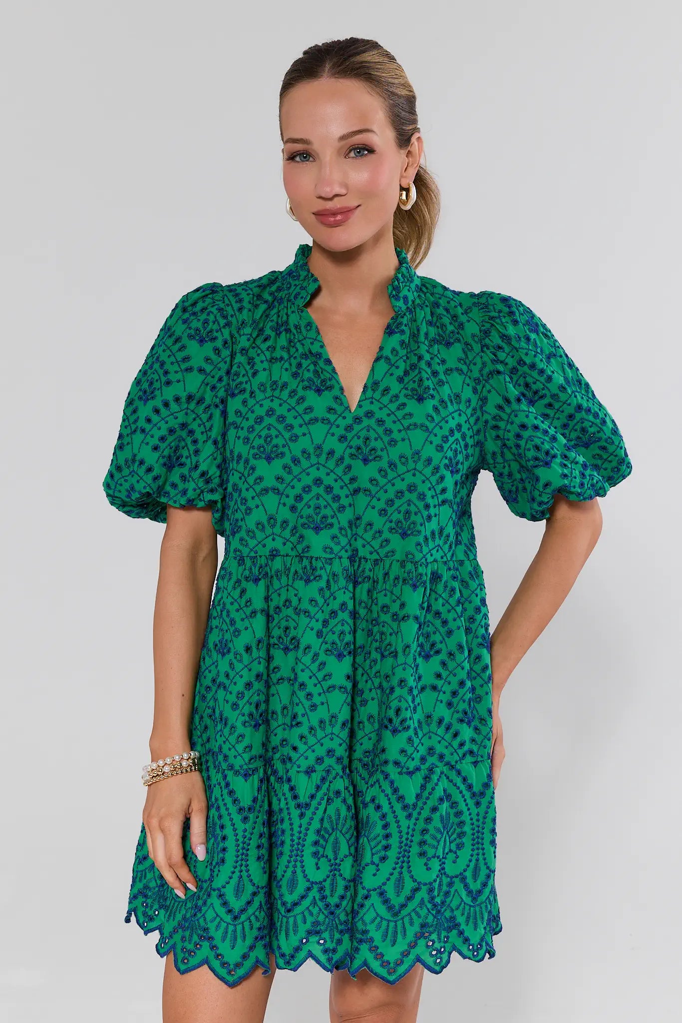 Woman wearing a green patterned dress against a white background
