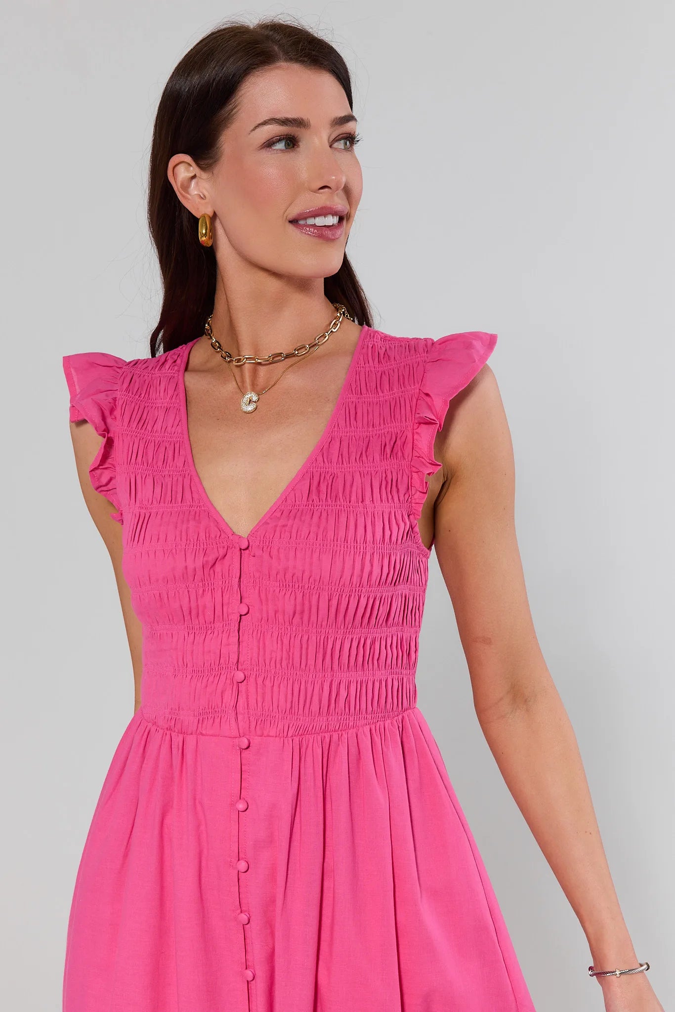 close up Woman wearing a pink dress against a plain background