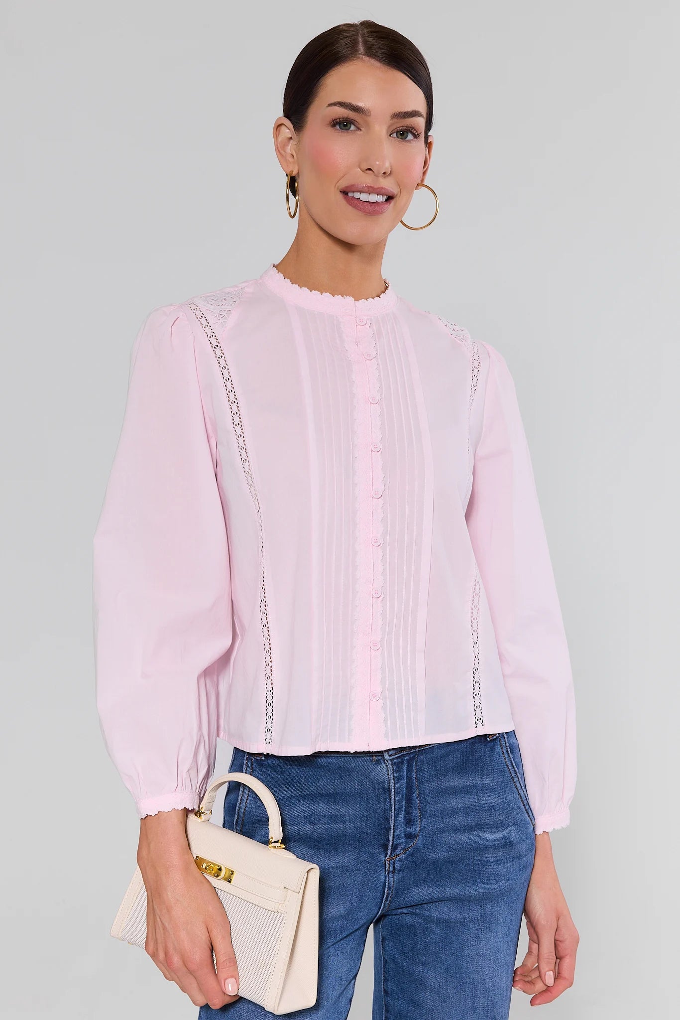 Woman wearing a light pink blouse with a white background