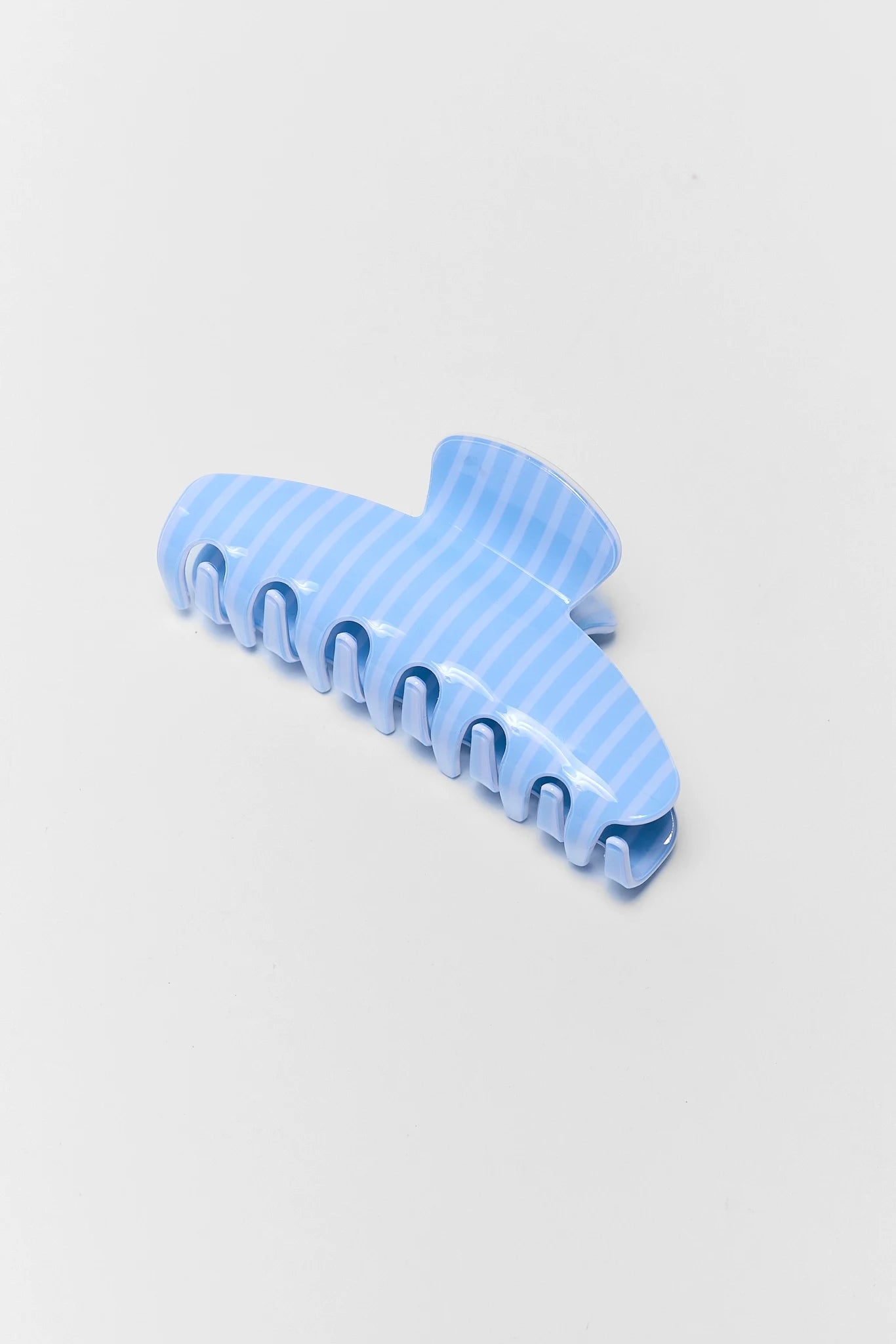 Blue striped hair clip on a light gray background