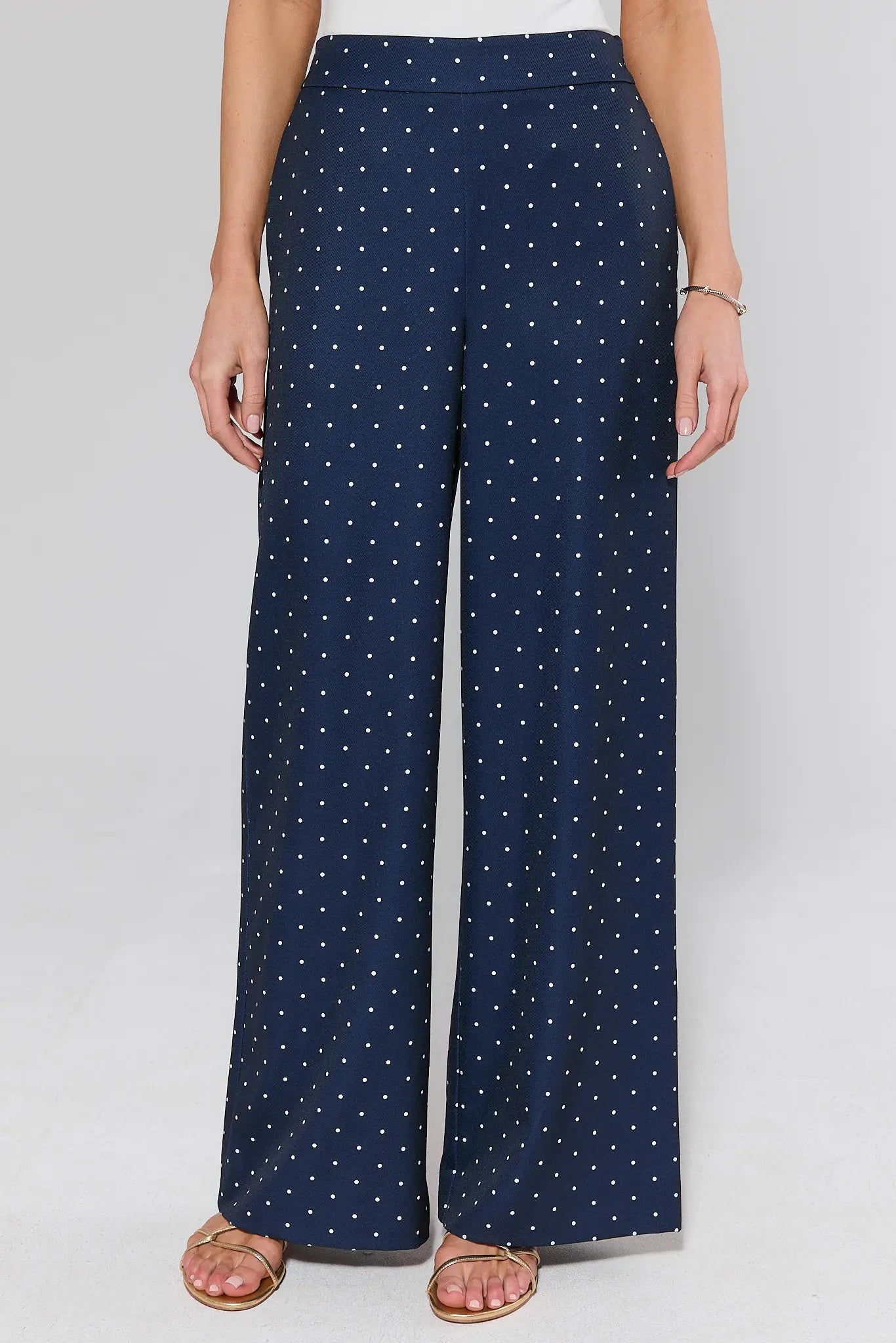 Navy blue pants with white star pattern worn by a person on a light gray background