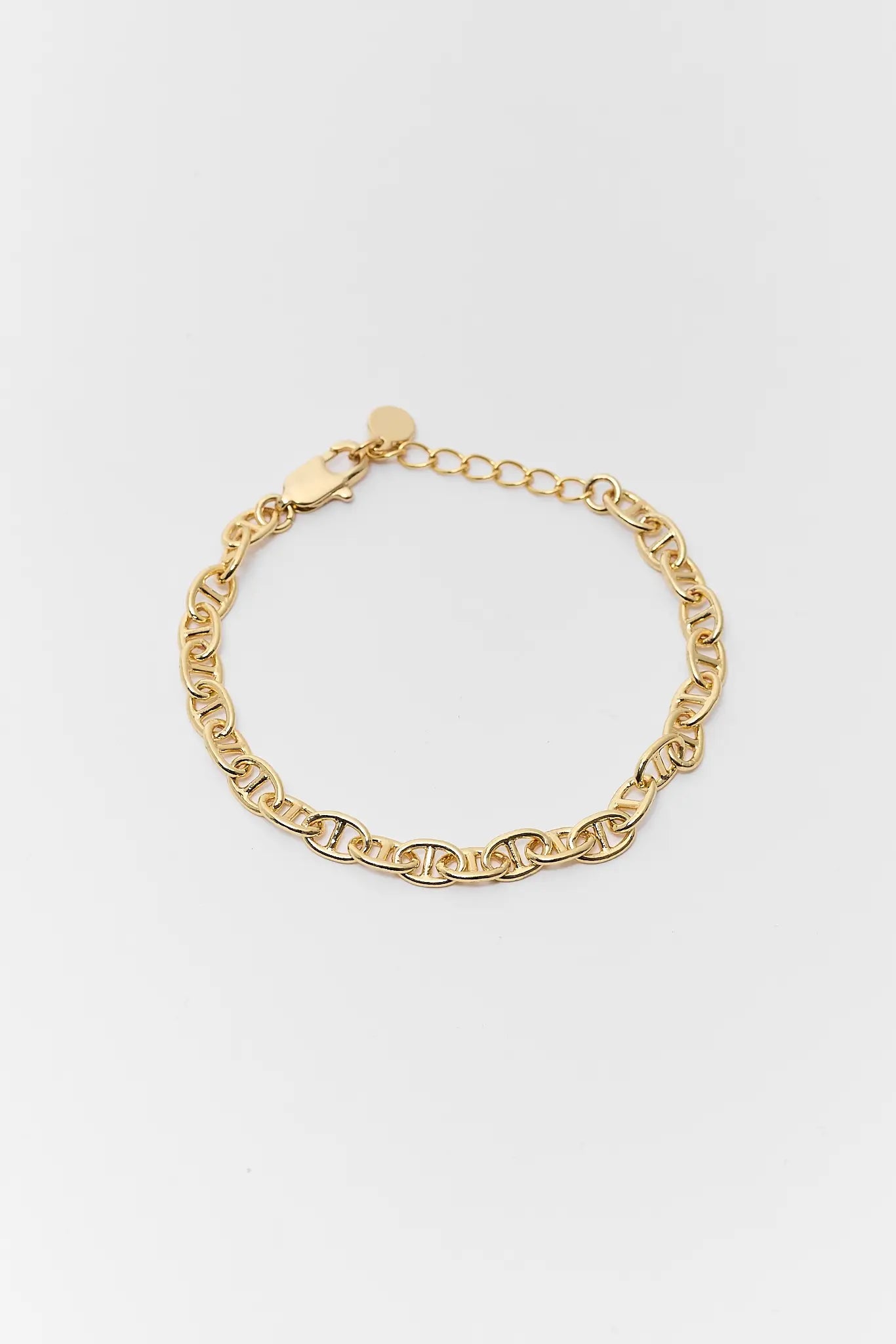 Gold chain bracelet on a light gray background