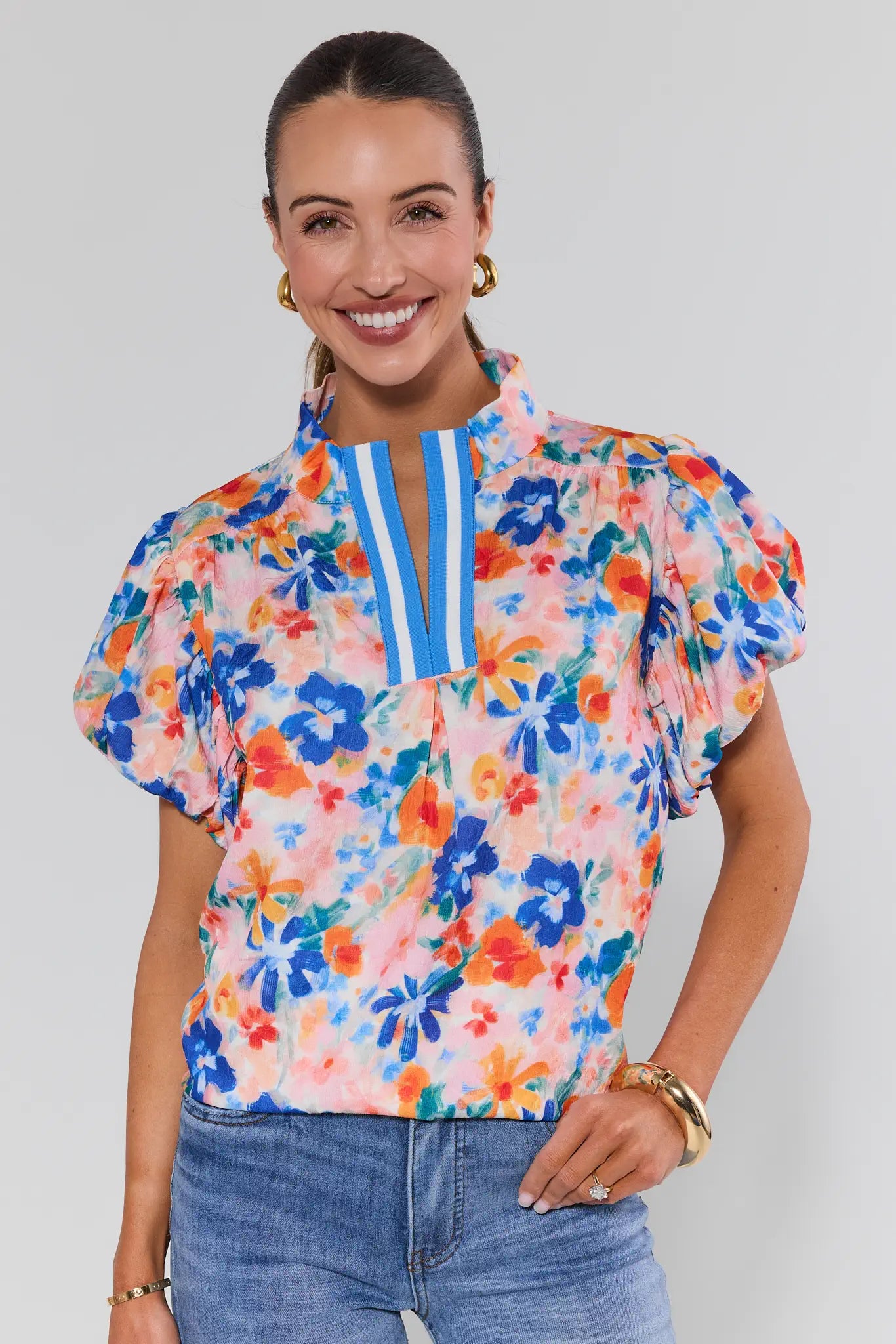 Woman wearing a colorful floral blouse with a white background