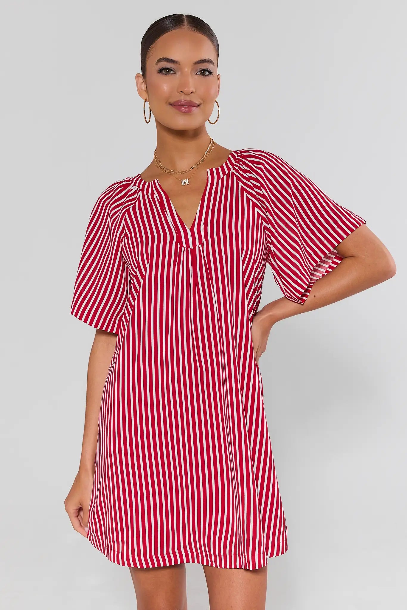 Woman wearing a red and white striped dress on a plain background
