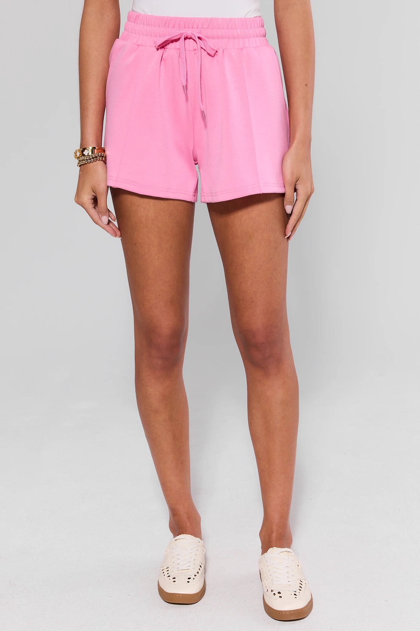 Person wearing pink lexi shorts on a plain background