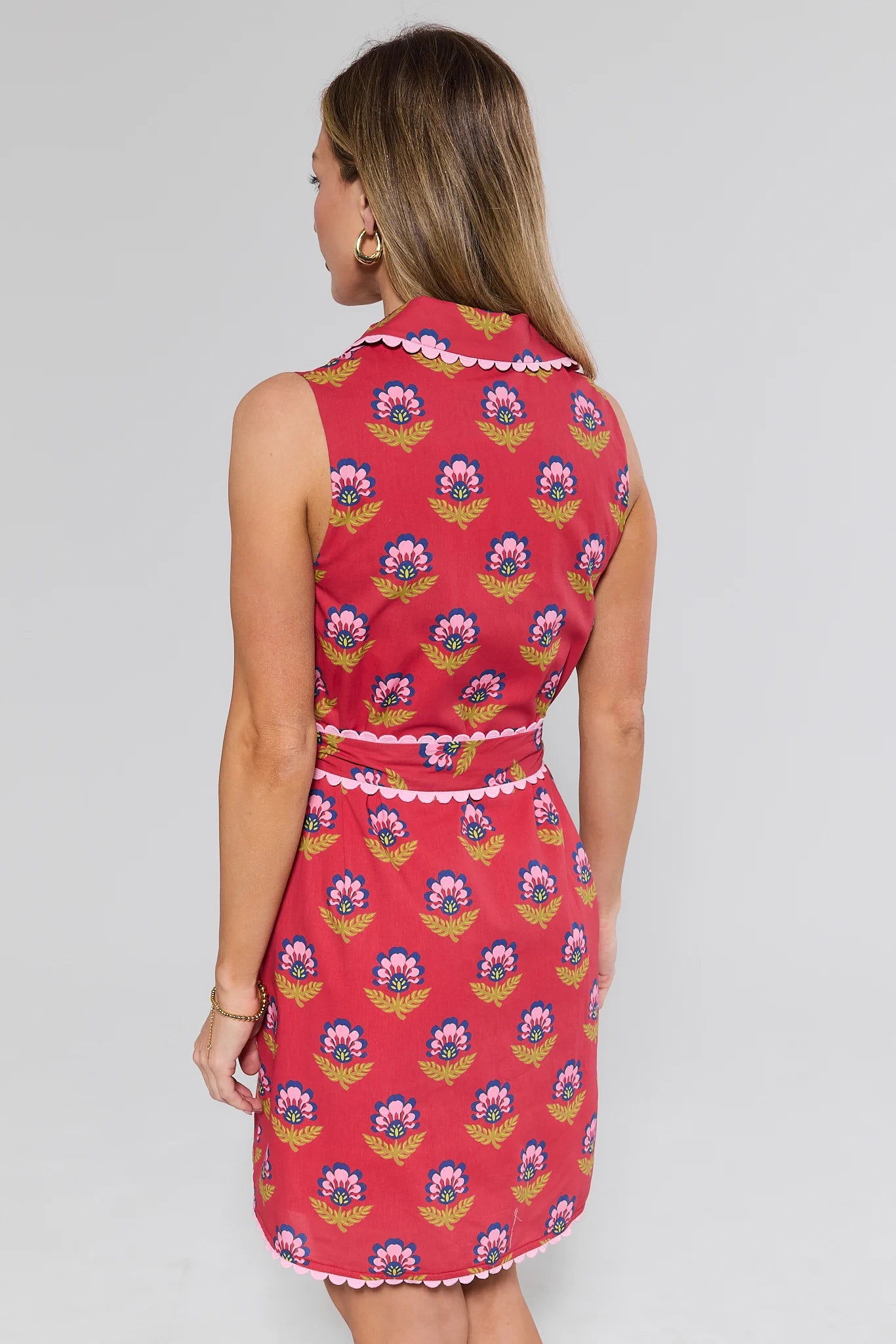 Woman wearing a red floral dress against a gray background