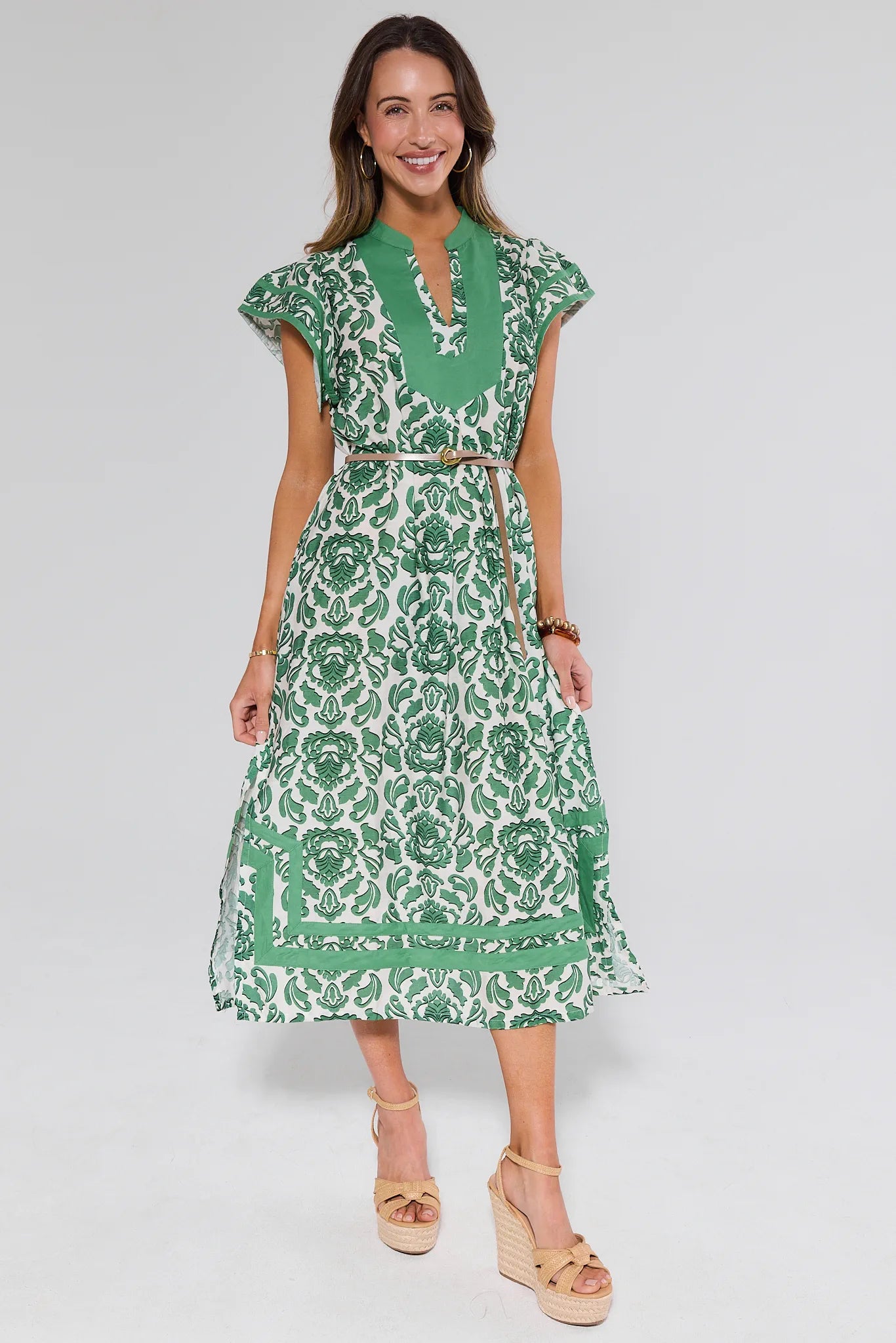 Woman wearing a green floral dress on a gray background