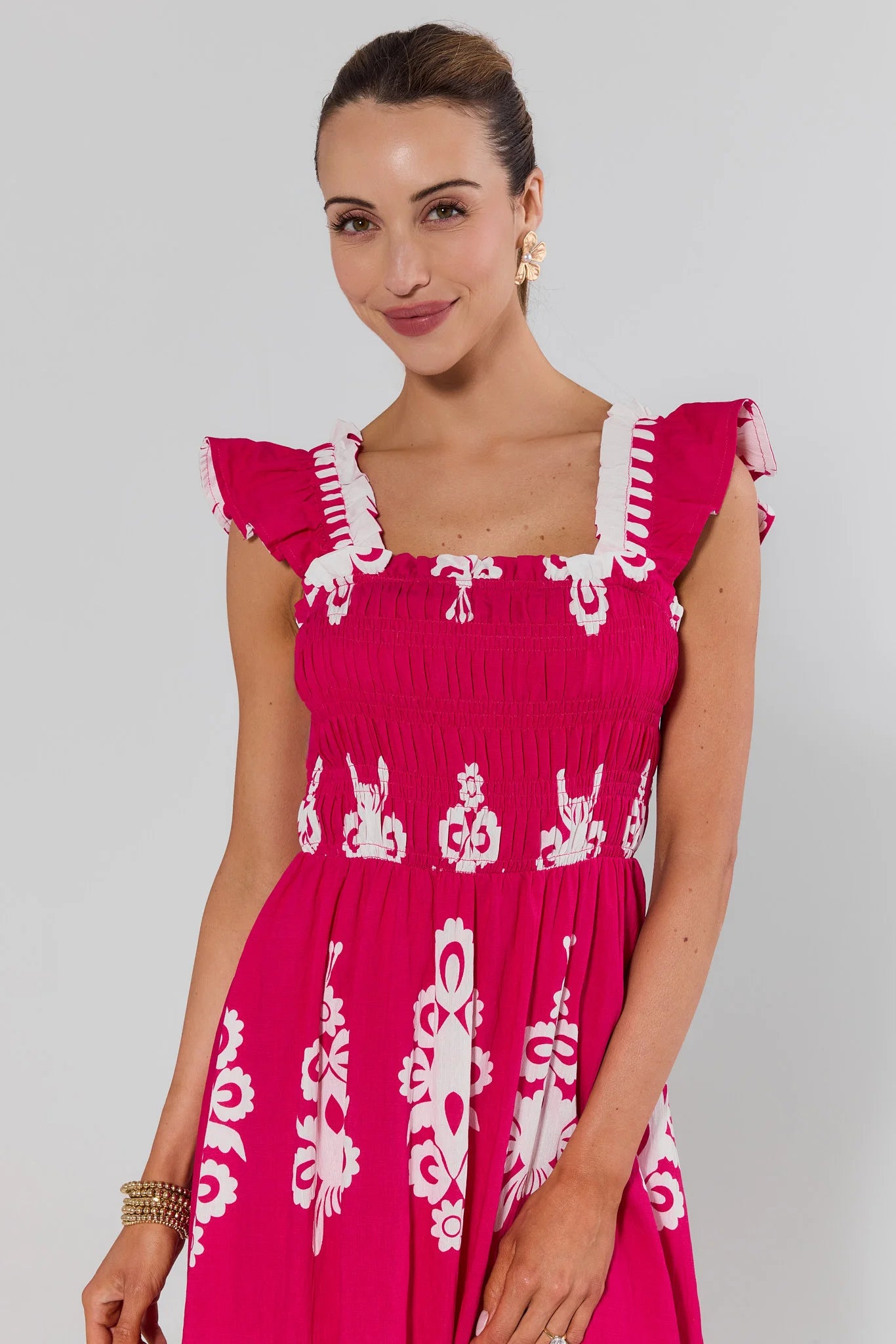 close up Woman wearing a pink dress with white patterns on a gray background