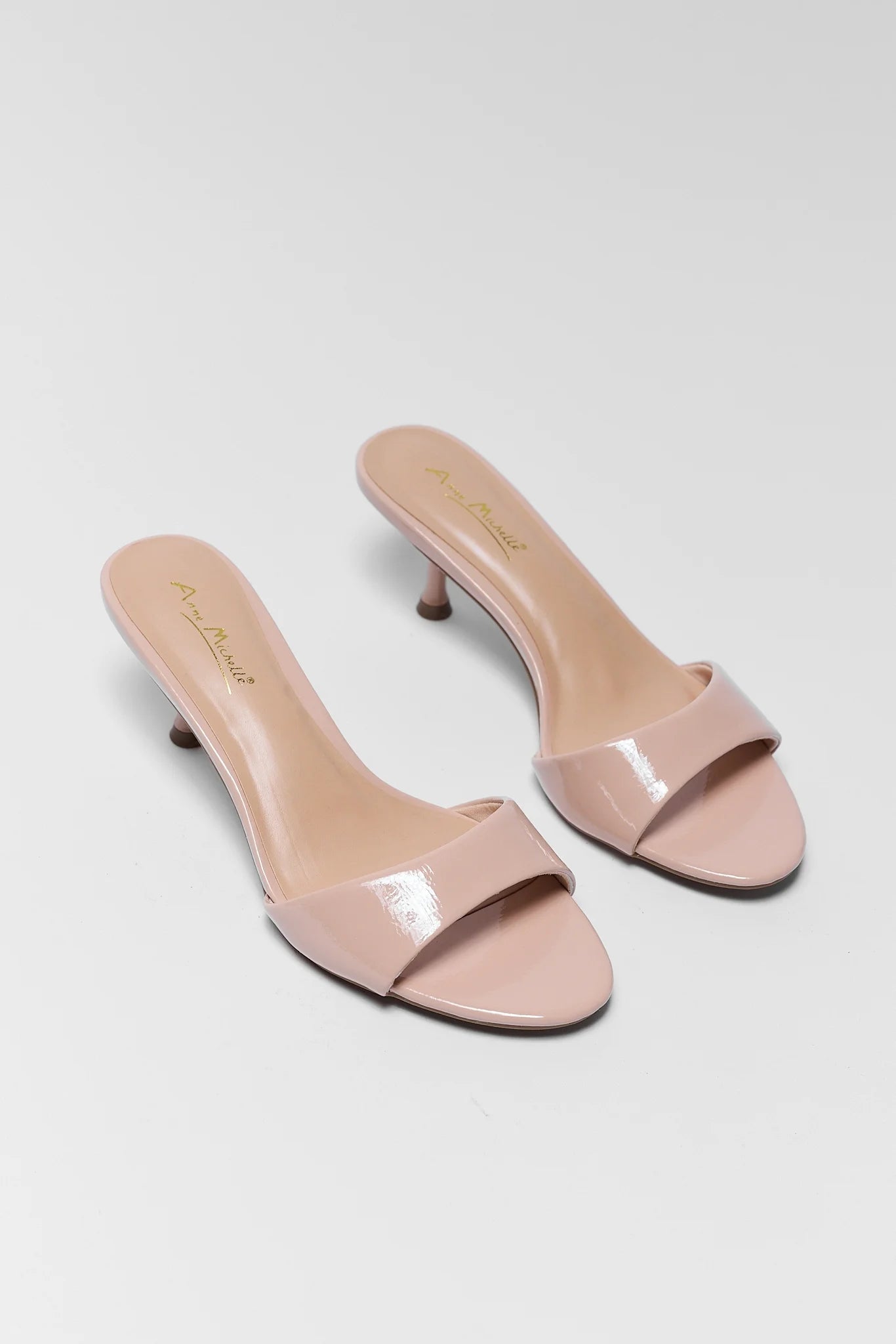 Pair of pink high-heeled shoes on a gray background