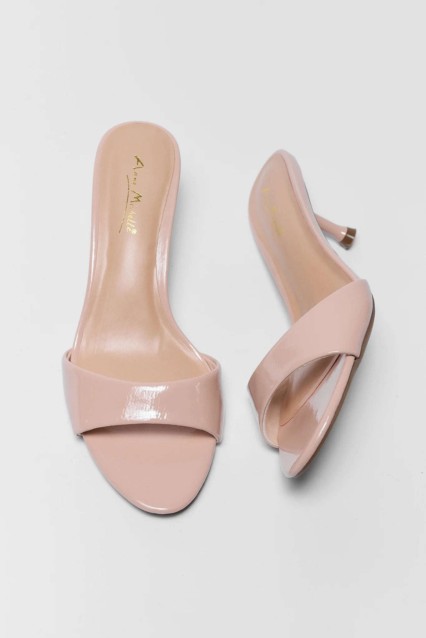 Pair of nude high-heeled shoes on a light gray background