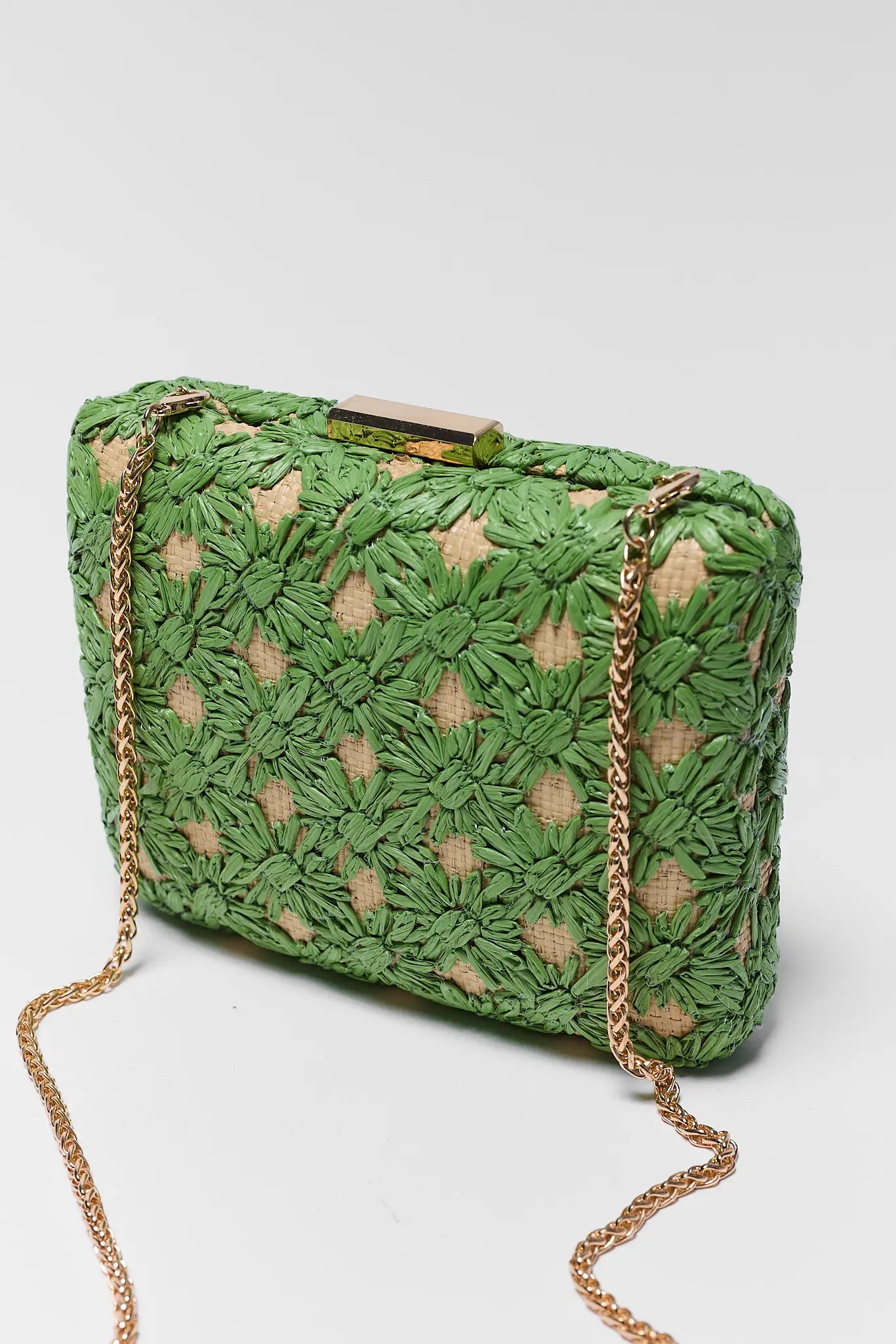 Green woven clutch bag with gold chain strap on a white background