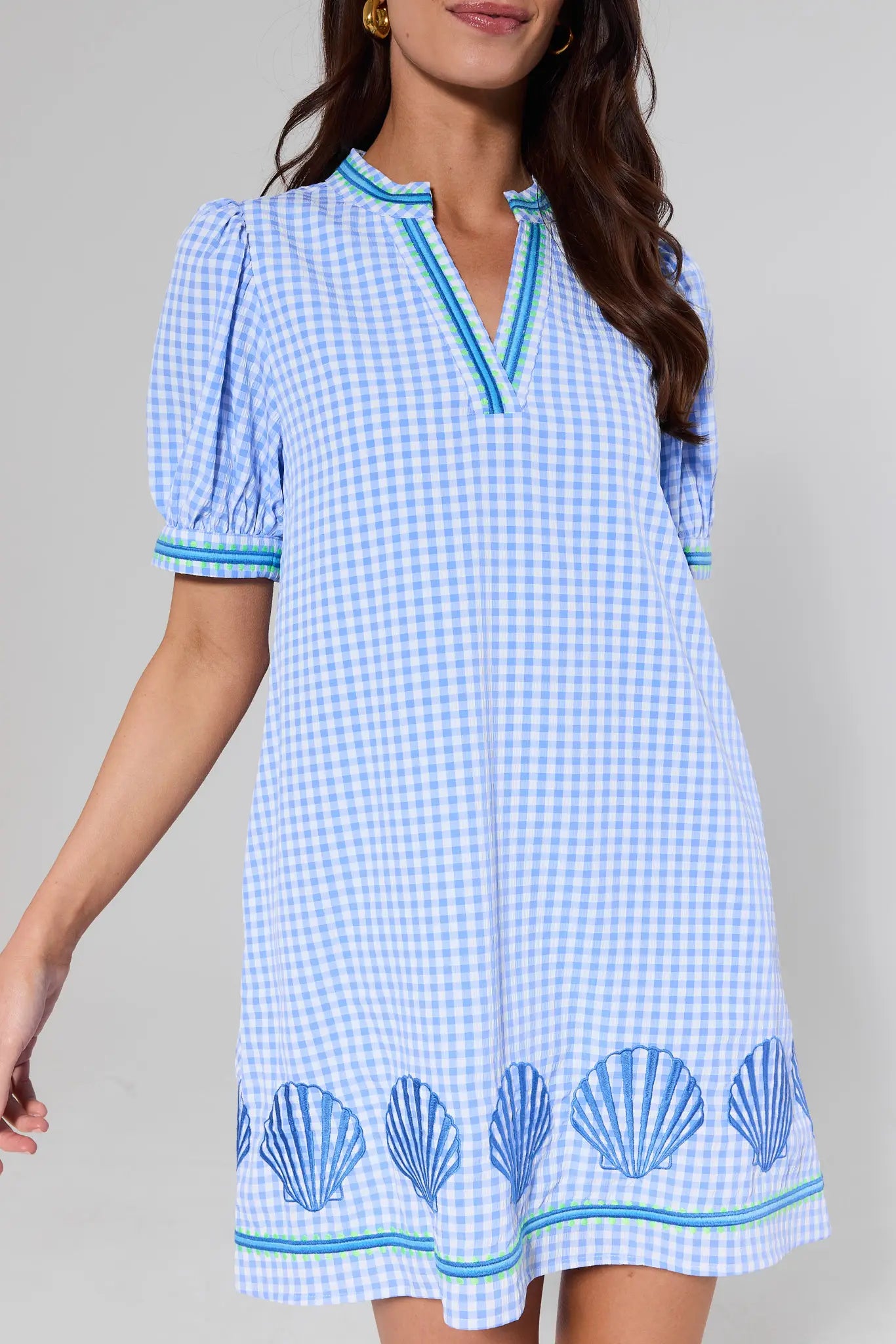 close up Woman wearing a blue and white checkered dress with shell patterns on a gray background