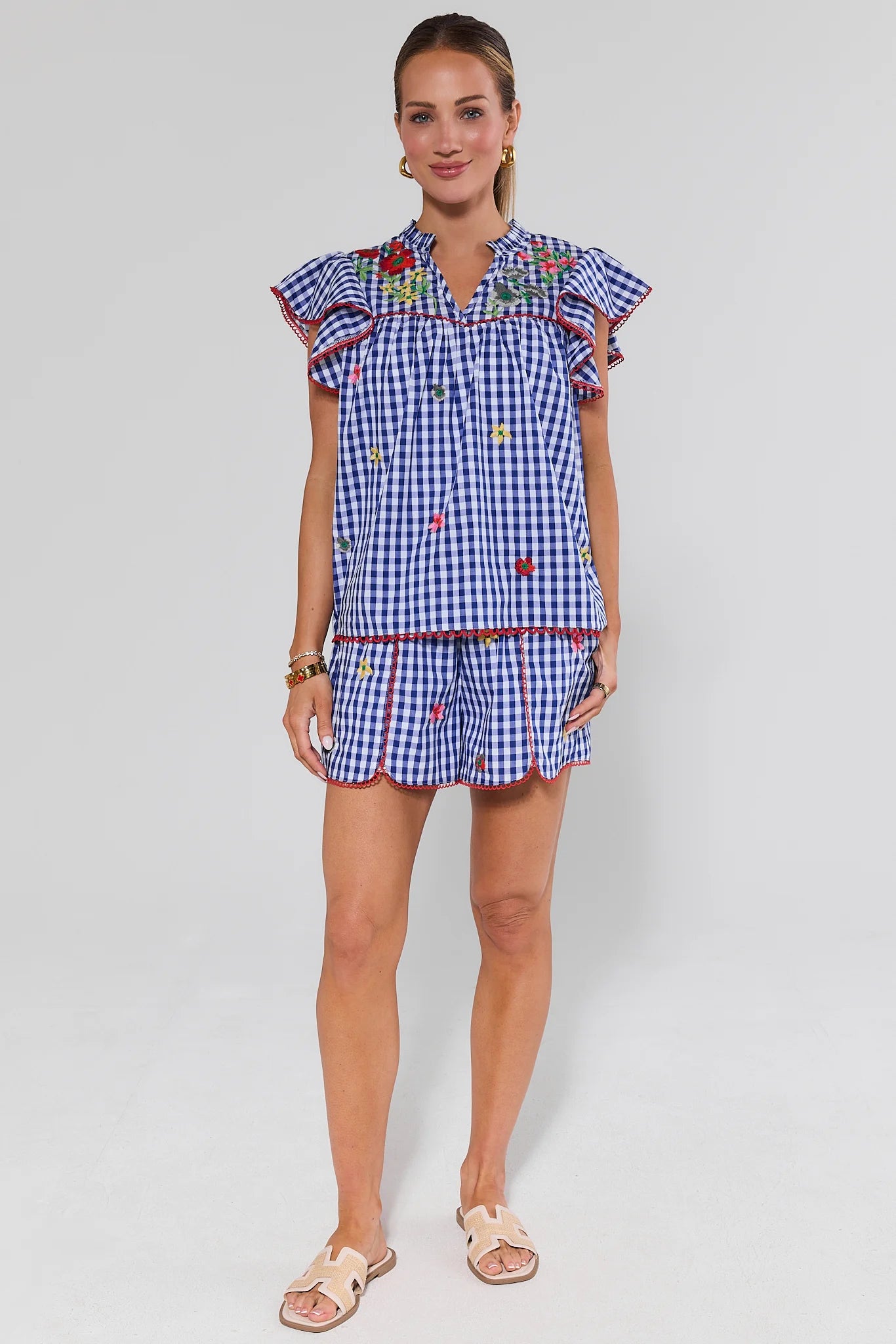 Woman wearing a blue checkered outfit with colorful accents on a white background