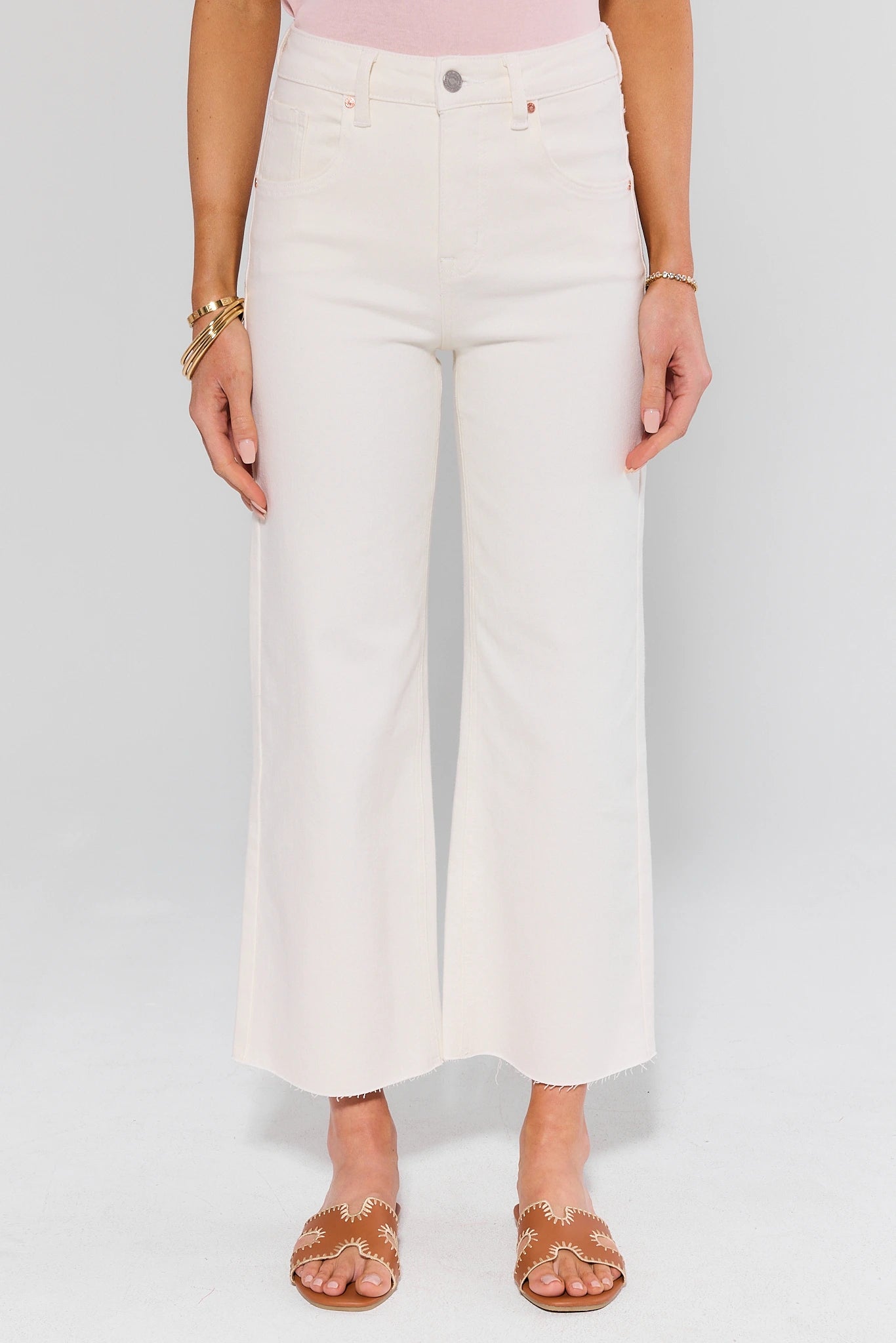 Person wearing white wide-leg jeans on a plain background