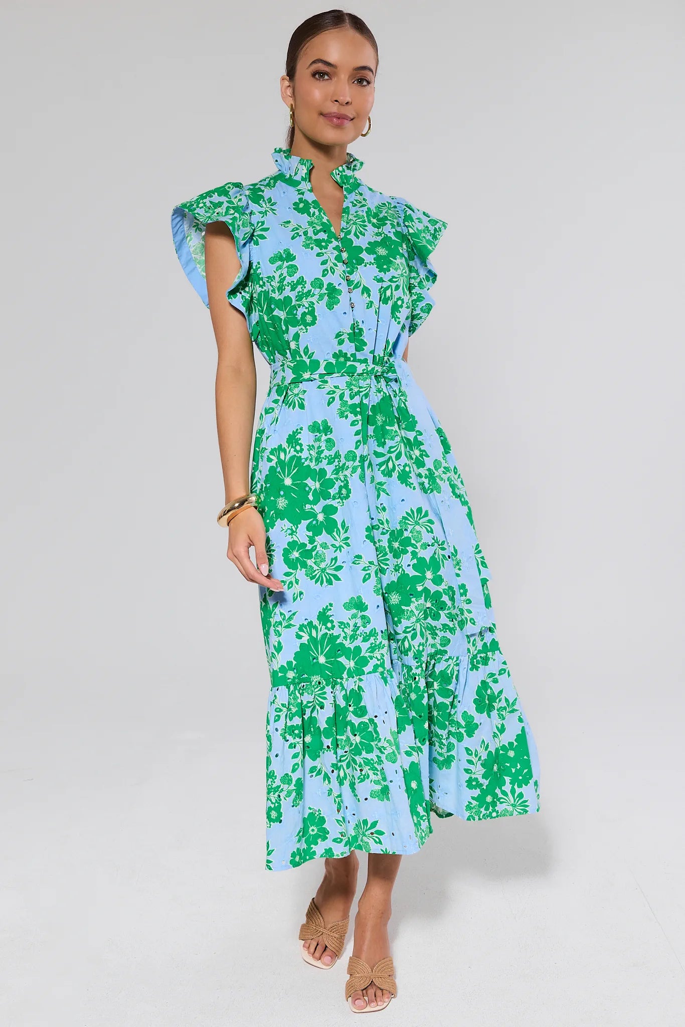 Woman wearing a green and blue floral dress on a white background