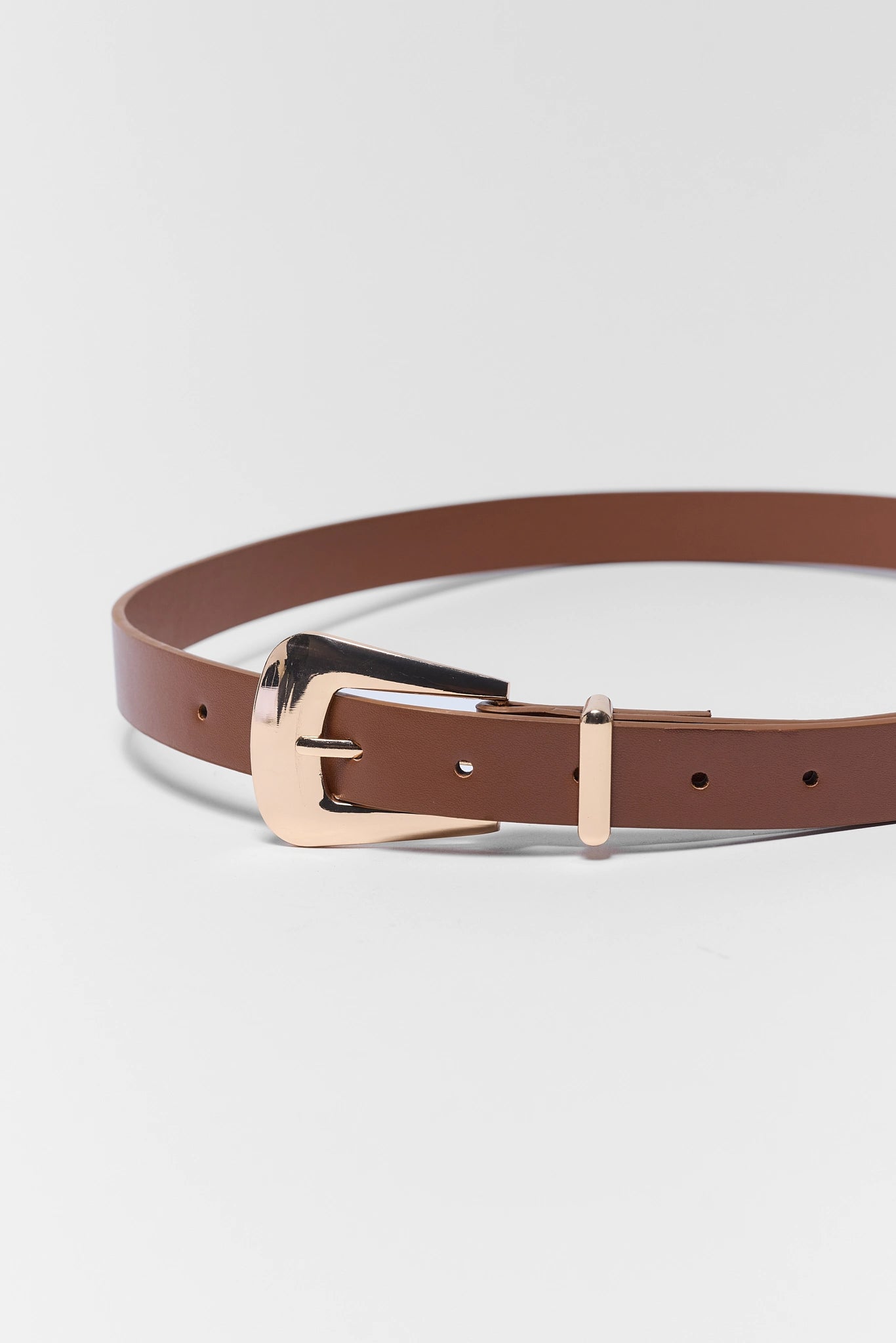 Brown belt with a rose gold buckle on a light gray background
