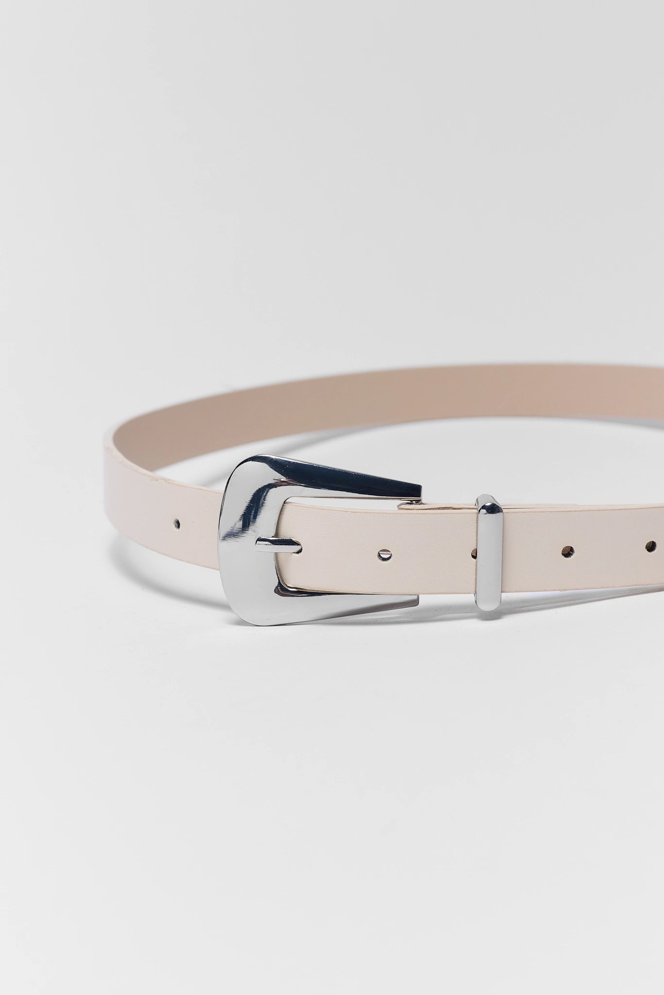 Beige belt with a silver buckle on a light gray background