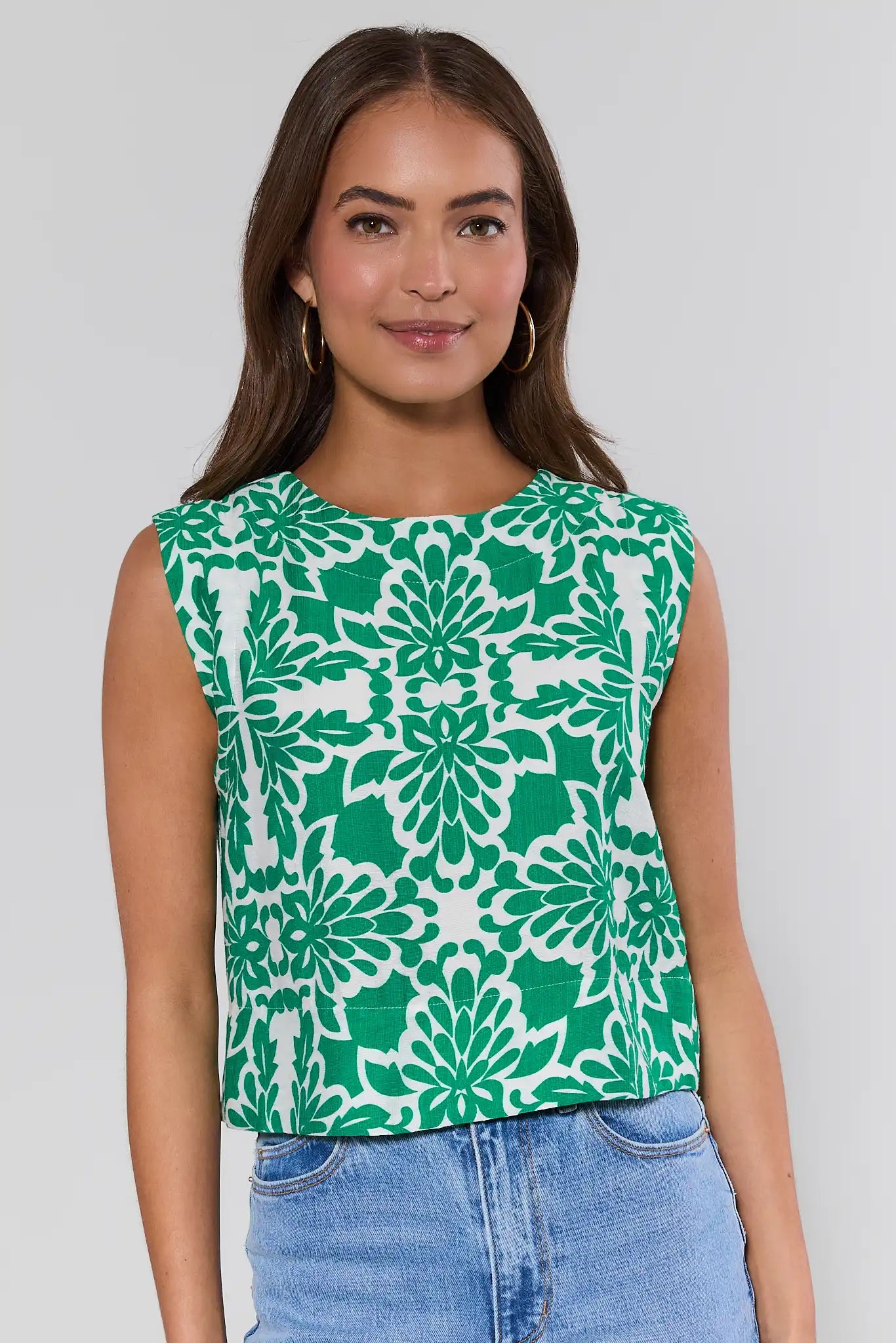 Woman wearing a green and white patterned top against a gray background