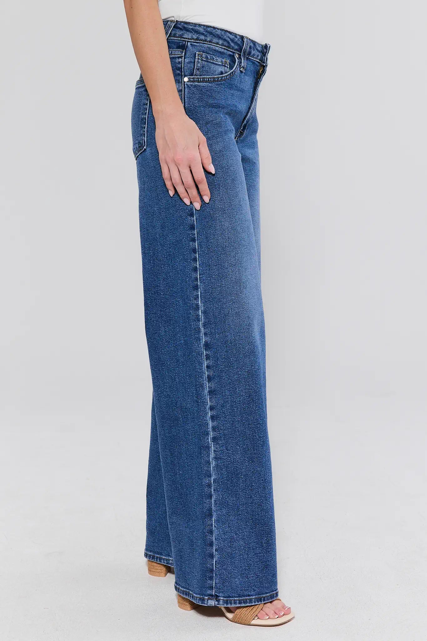 Blue jeans worn by a person on a light gray background