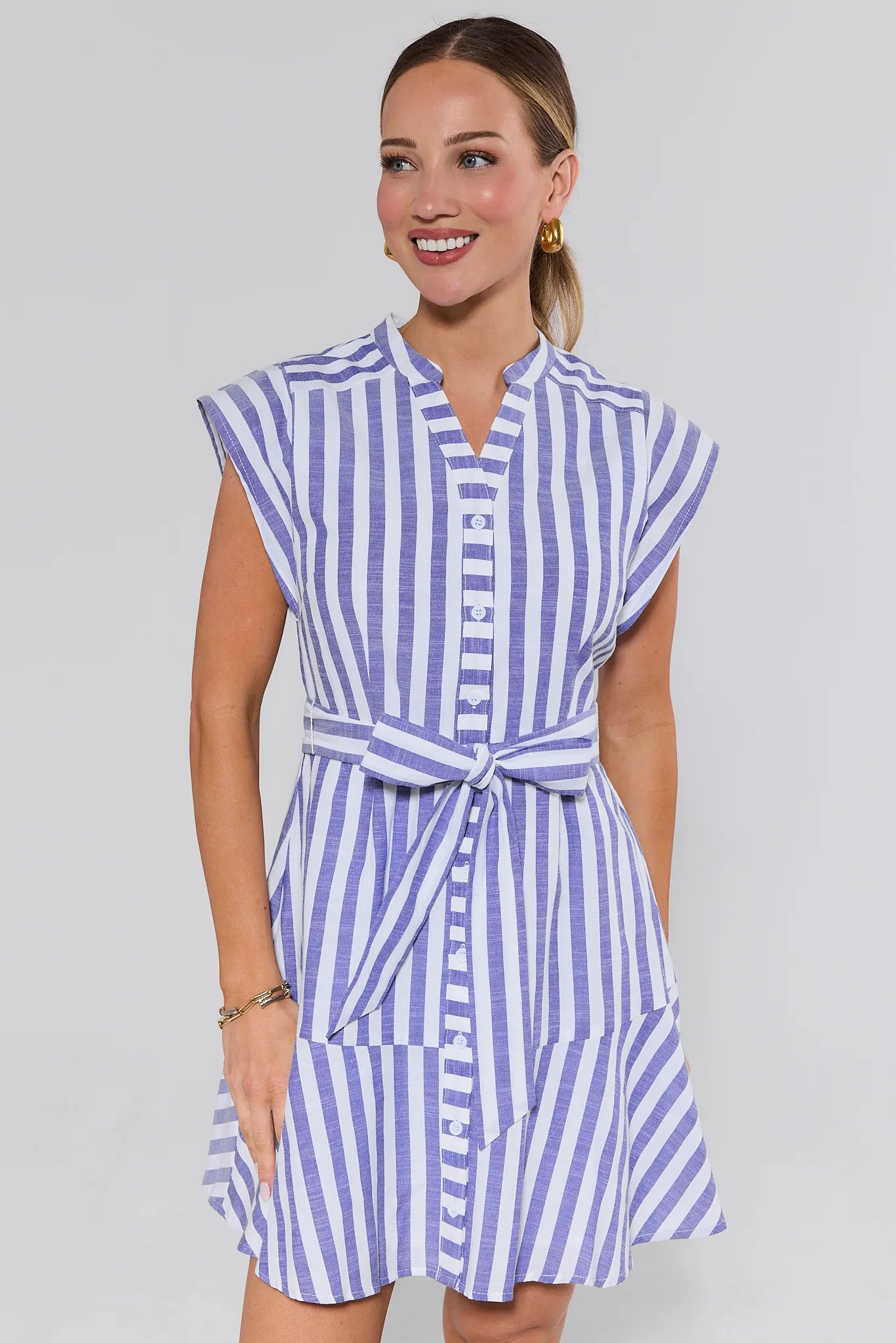 Woman wearing a blue and white striped dress on a gray background