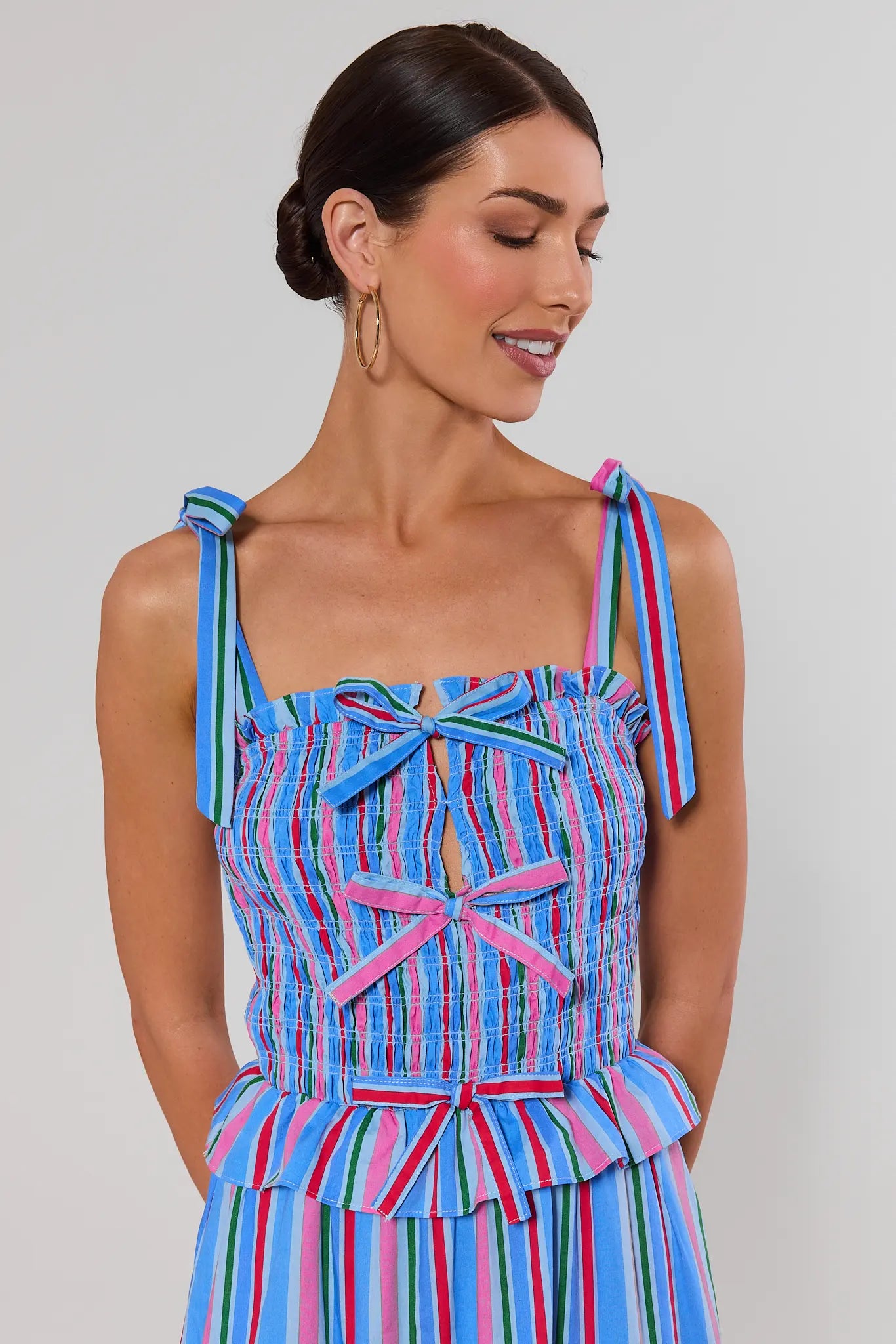 close up Woman wearing a colorful striped dress against a gray background