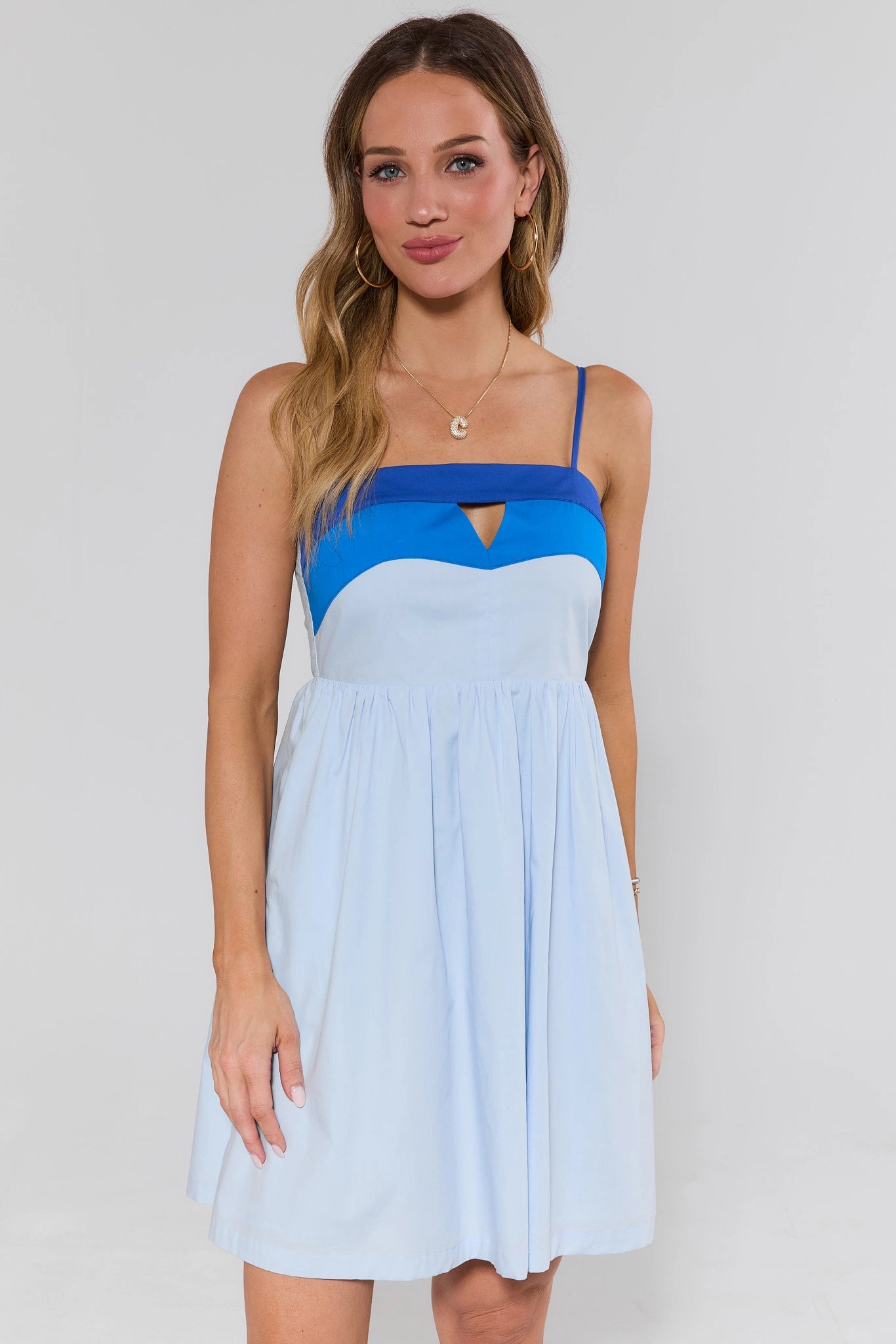 Woman wearing a blue and light blue dress against a white background