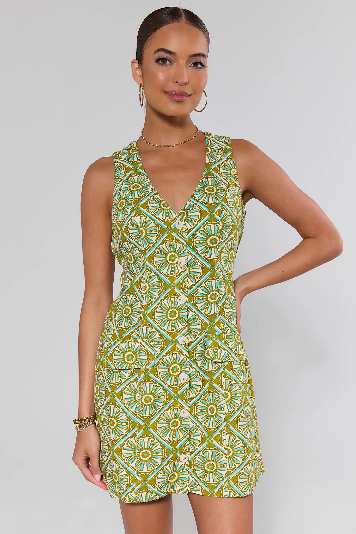 Woman wearing a green and yellow patterned dress on a white background