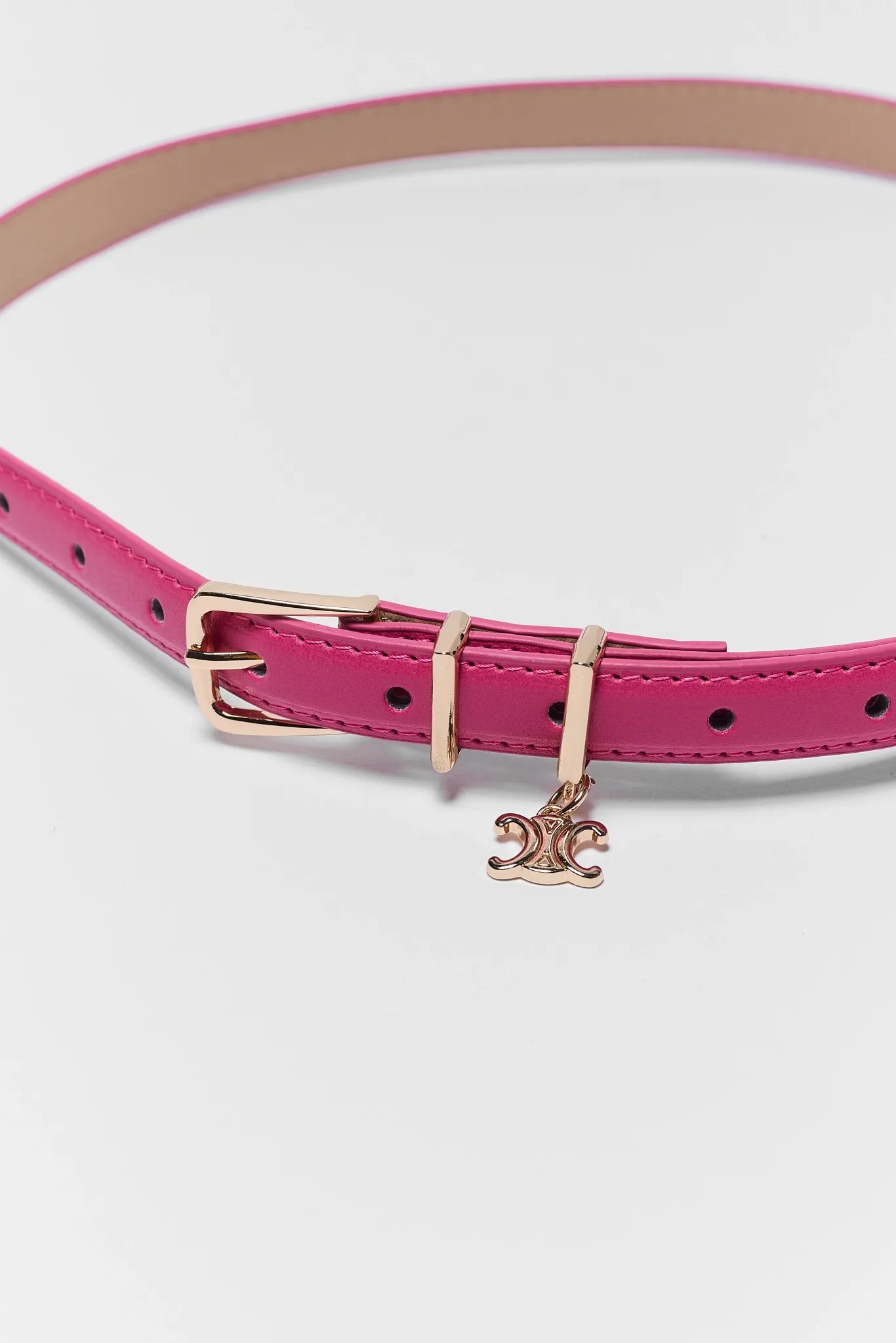 Pink dog collar with a gold buckle and charm on a white background
