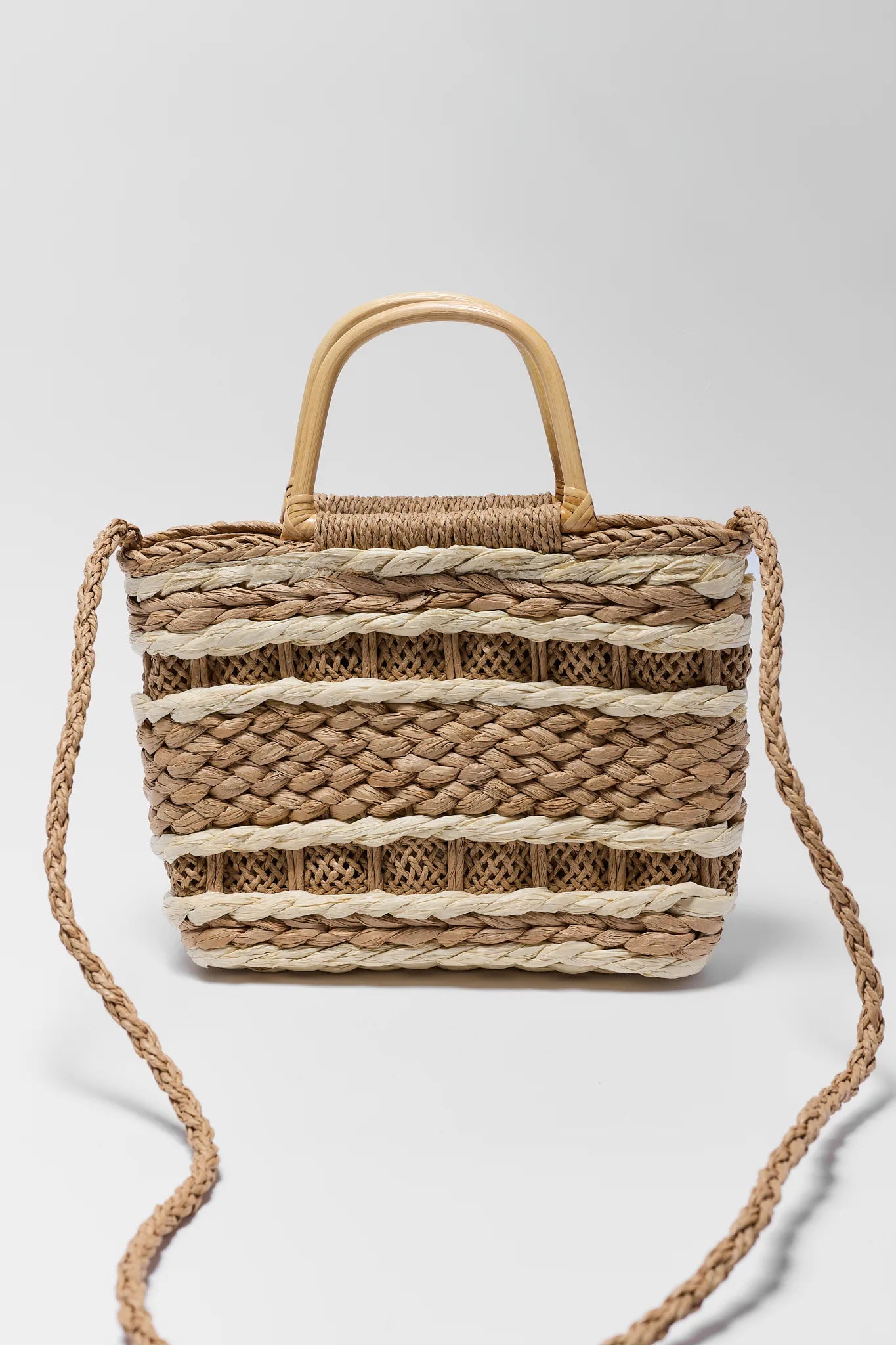 Woven handbag with striped pattern on a light gray background