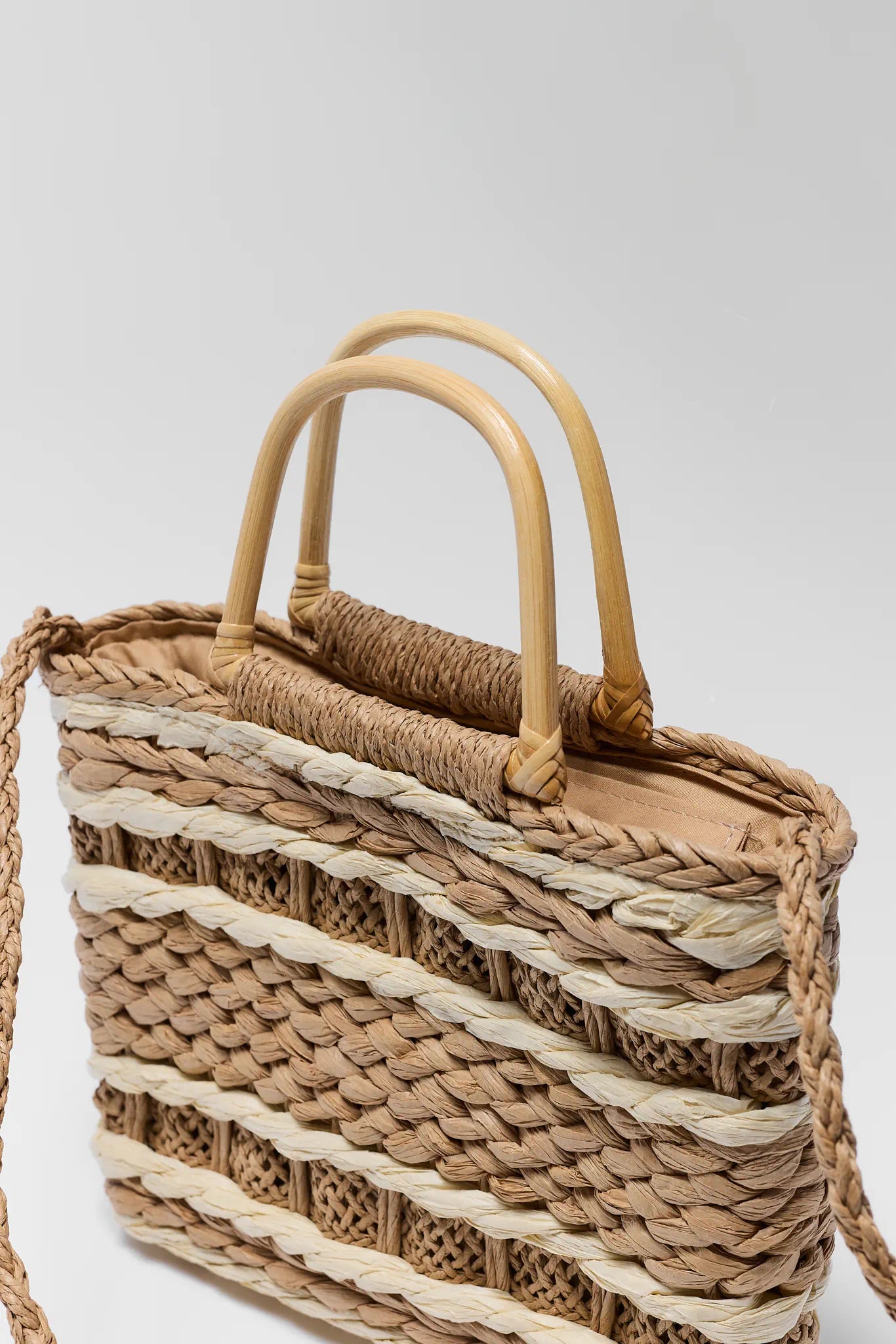 Woven handbag with natural materials on a light gray background