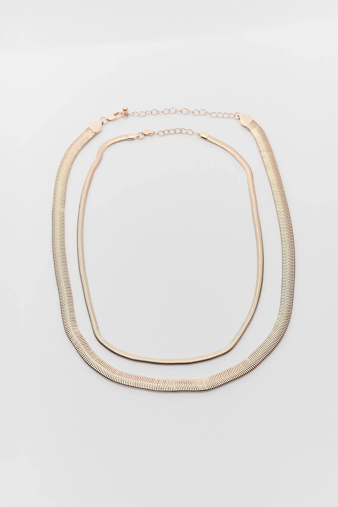 Gold necklace on a light gray background