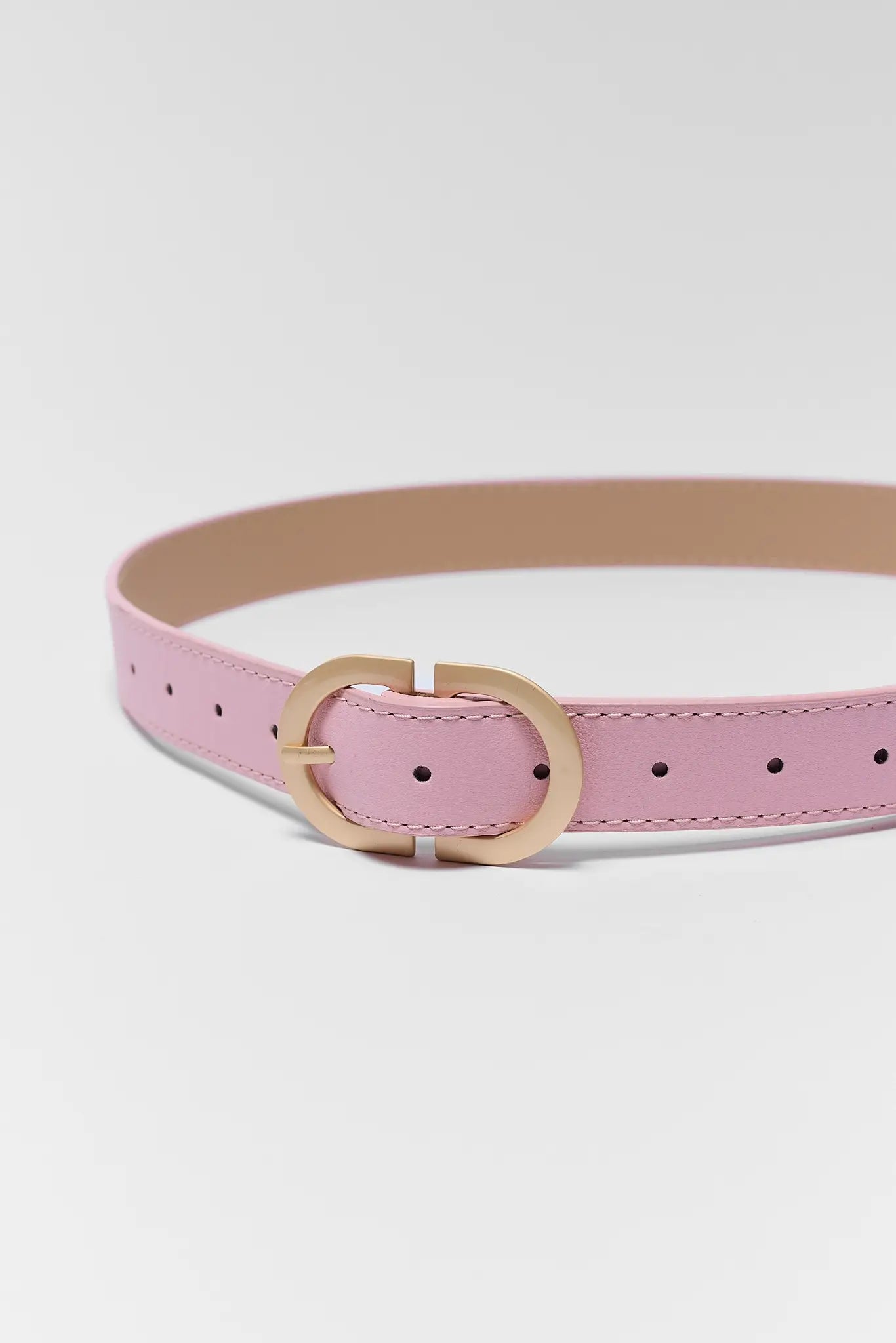 Pink belt with a gold buckle on a white background