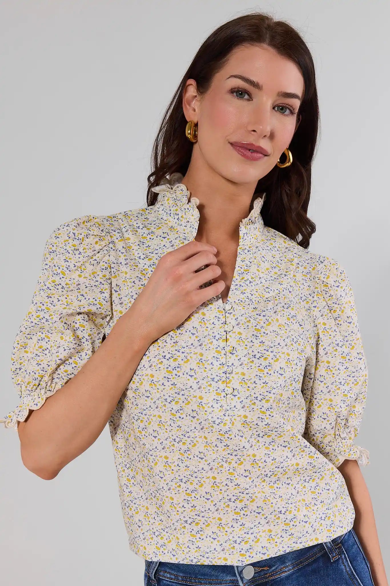 close up Woman wearing a floral blouse against a plain background
