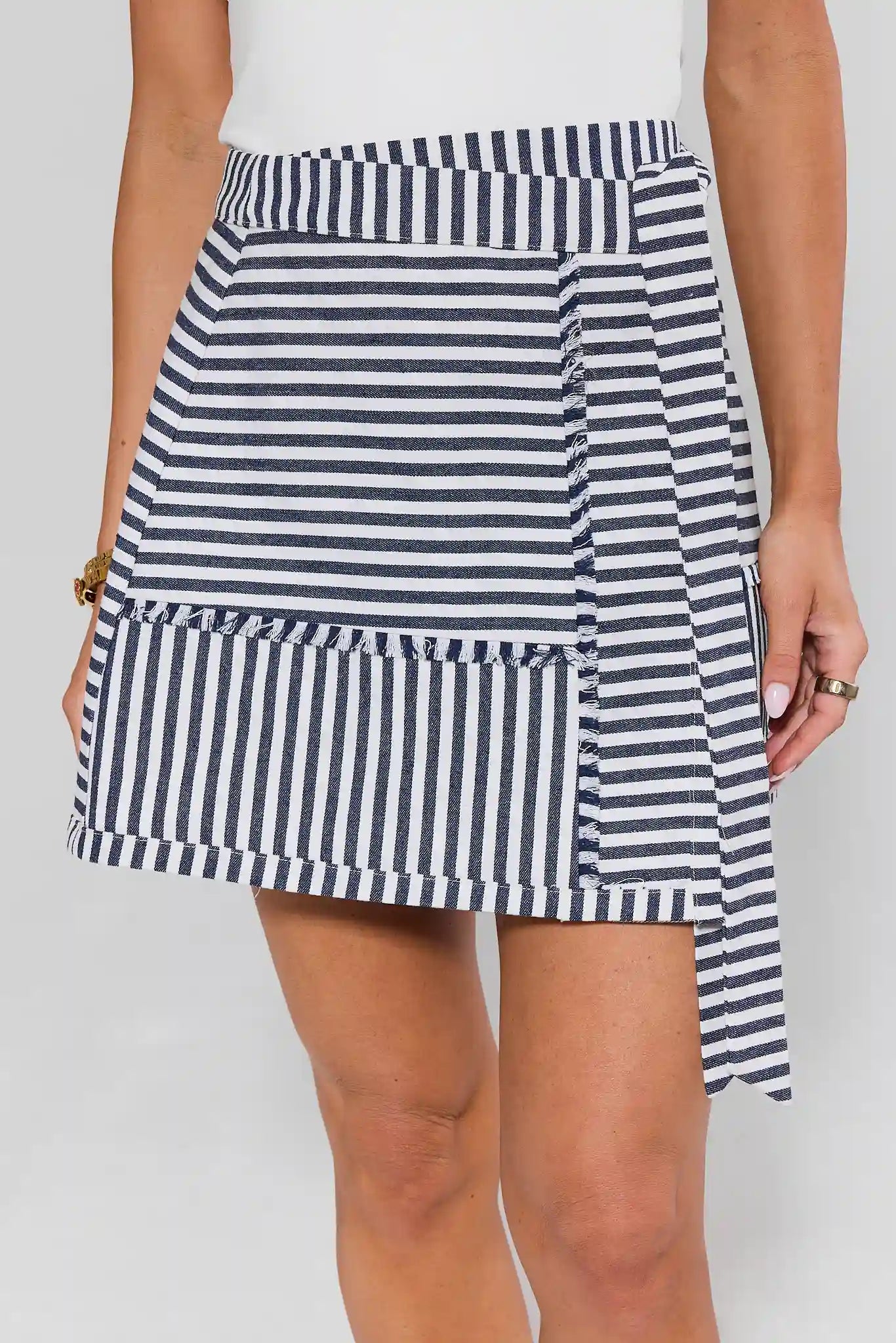 Navy and white striped skirt worn by a person on a plain background