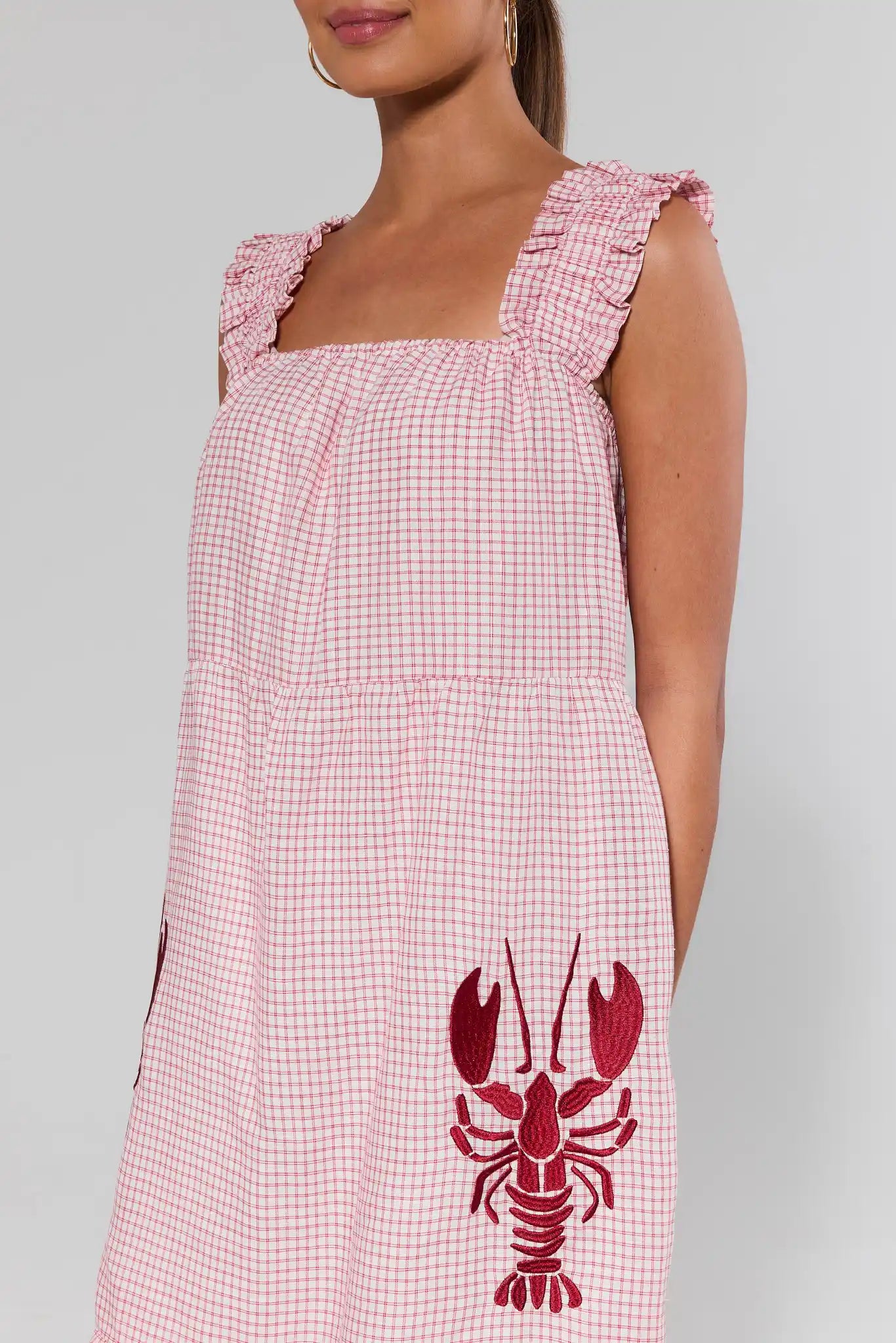 close up Red checkered dress with a lobster design on a gray background