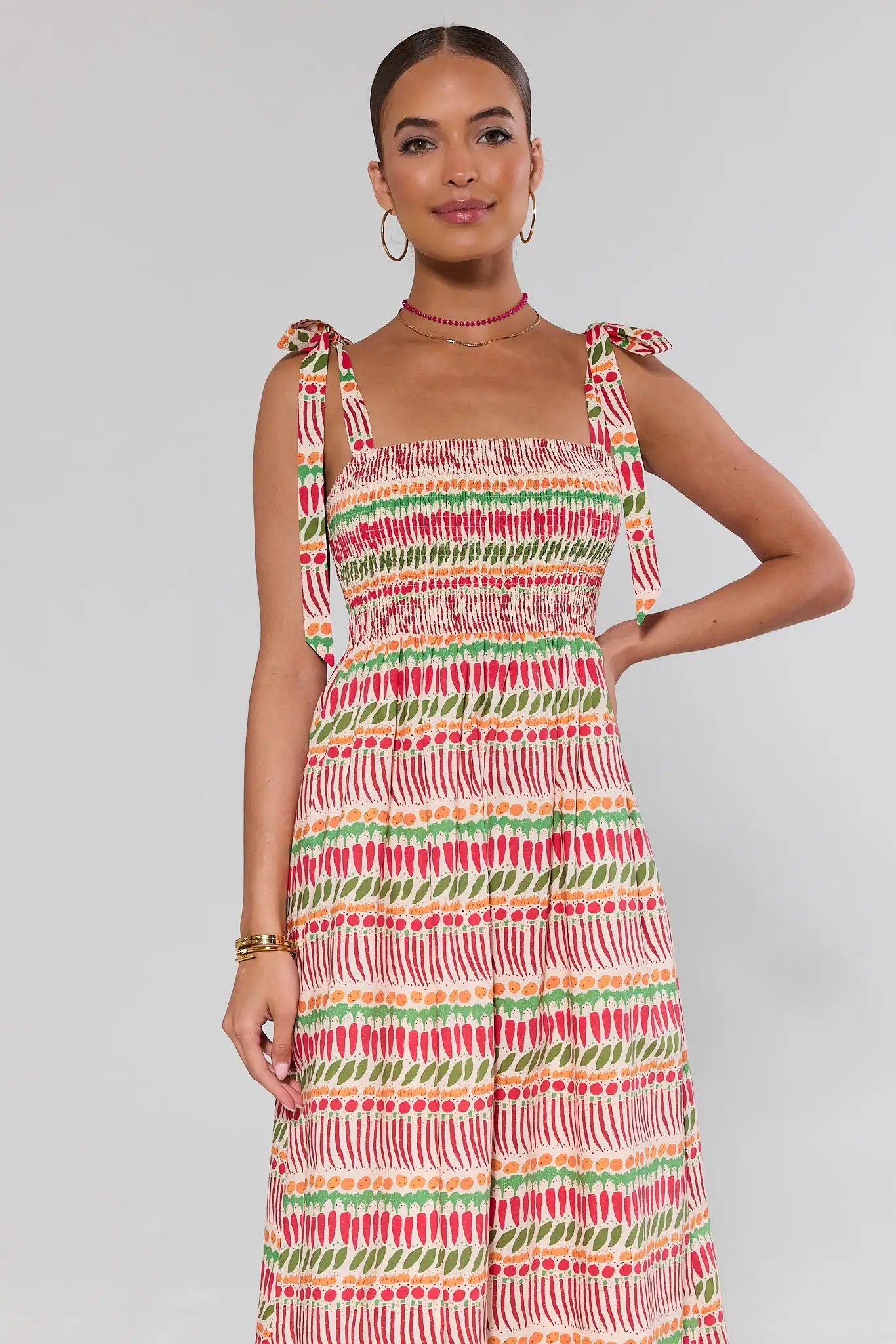Woman wearing a colorful patterned dress on a plain background