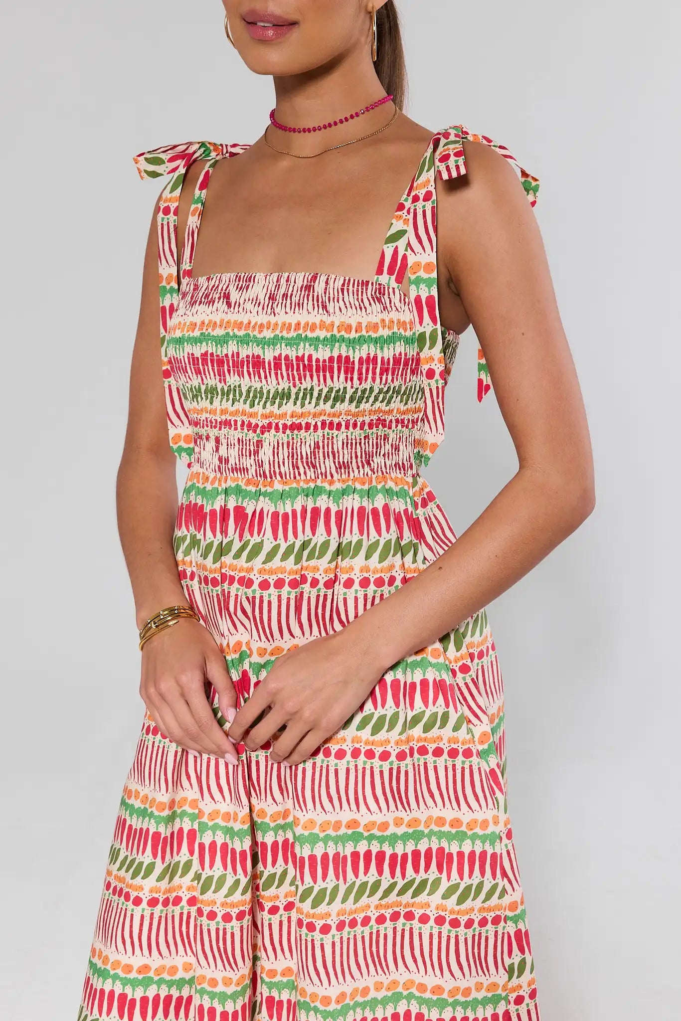 close up Woman wearing a colorful patterned dress against a plain background