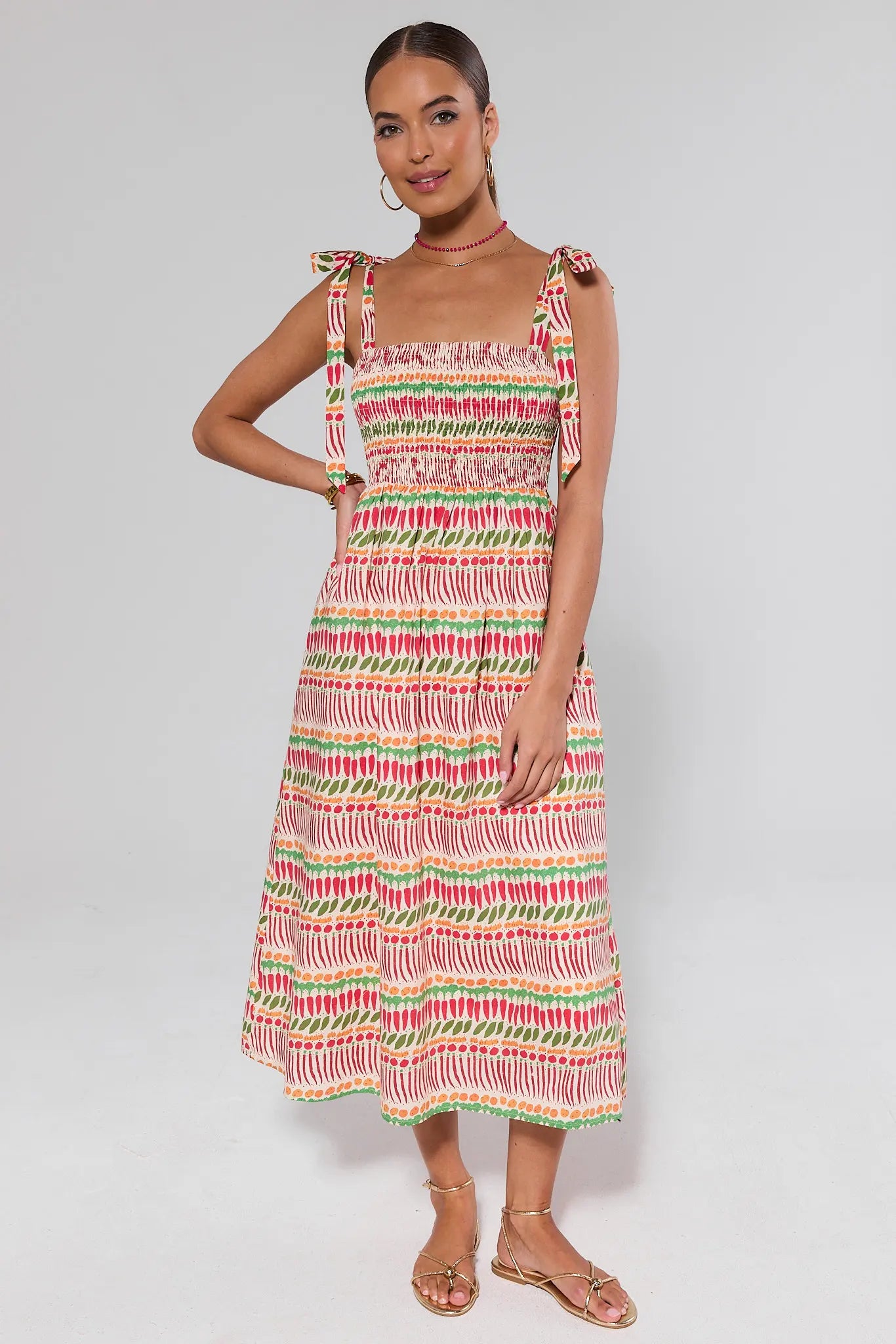 Woman standing wearing a colorful striped dress on a background